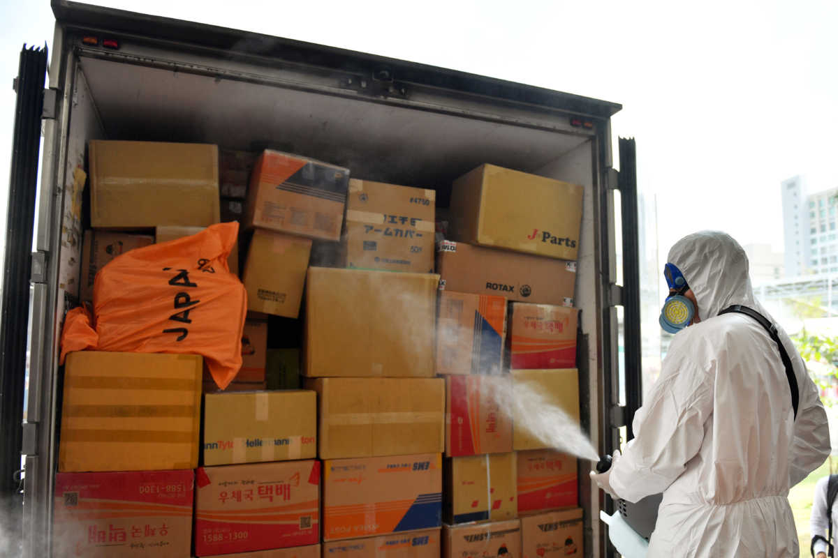 Postal worker disinfects packages arrived from overseas, to contain the spread of coronavirus in Bangkok, Thailand March 5, 2020. REUTERS