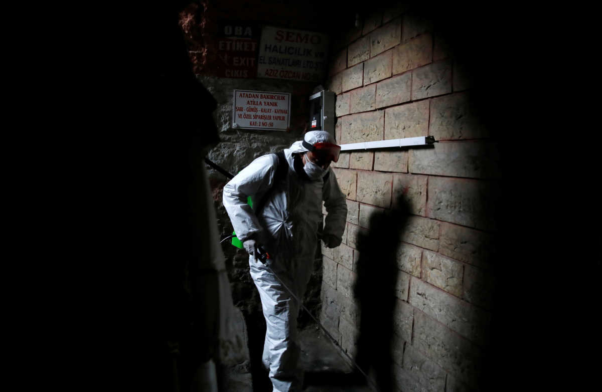 A worker in a protective suit sprays disinfectant at Grand Bazaar, known as the Covered Bazaar, to prevent the spread of coronavirus disease (COVID-19), in Istanbul, Turkey, March 25, 2020. REUTERS