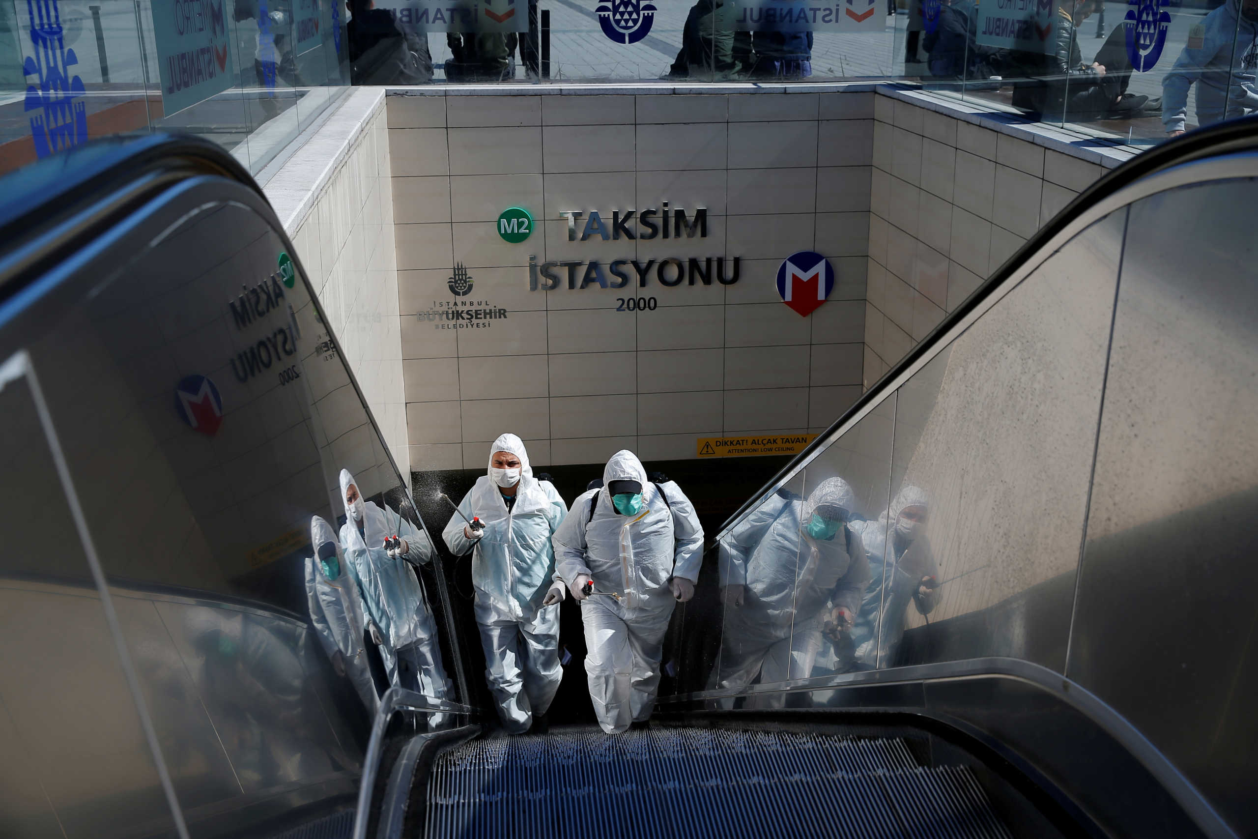 Municipality workers in protective suits disinfect entrance of Taksim metro station, due to coronavirus disease (COVID-19) concerns, in central Istanbul, Turkey, March 17, 2020. REUTERS