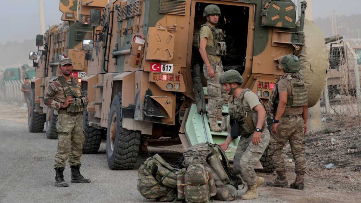 Turkish soldiers stand near military vehicles in the border town of Akcakale in Sanliurfa province, Turkey, October 11, 2019. REUTERS