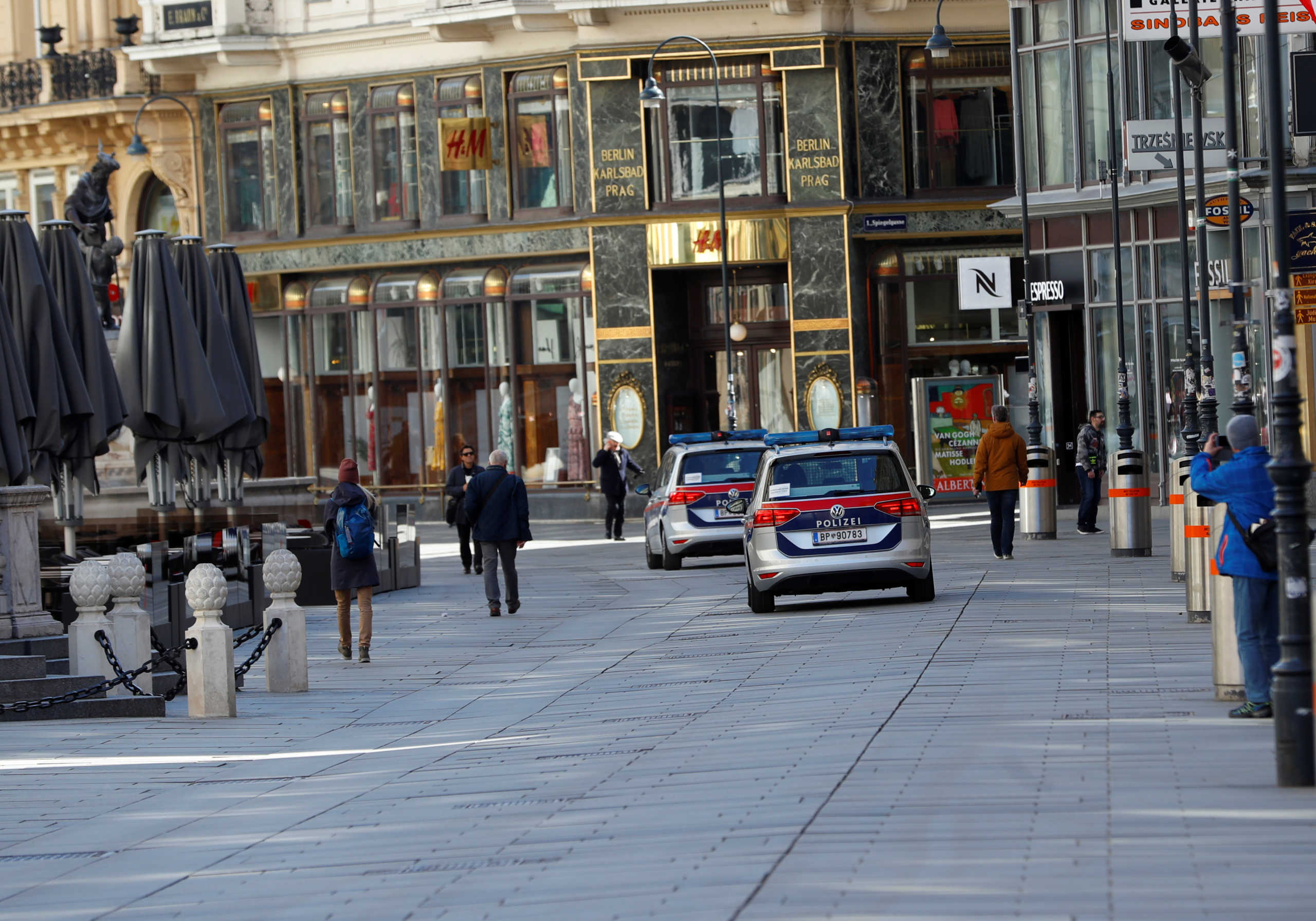 Police cars pass closed shops after the government closed shops and restaurants and asked people to stay at home amid the fears of coronavirus disease (COVID-19), in Vienna, Austria March 16, 2020.   REUTERS