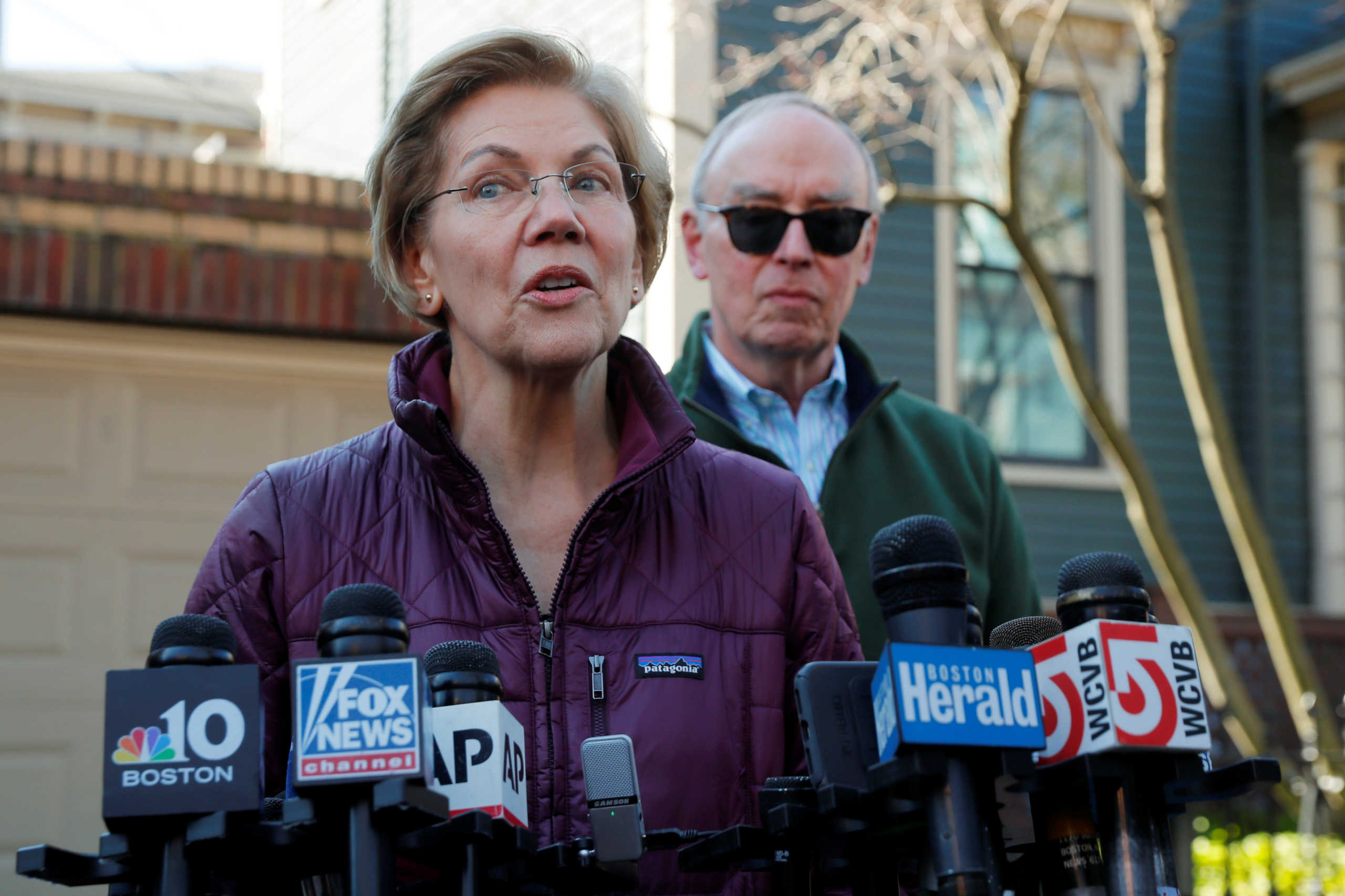 Democratic U.S. presidential candidate Senator Elizabeth Warren talks to reporters outside her house about the end of her campaign for U.S. president with her husband Bruce behind her after informing her staff that she is withdrawing from the 2020 U.S. presidential race in Cambridge, Massachusetts, U.S., March 5, 2020. REUTERS