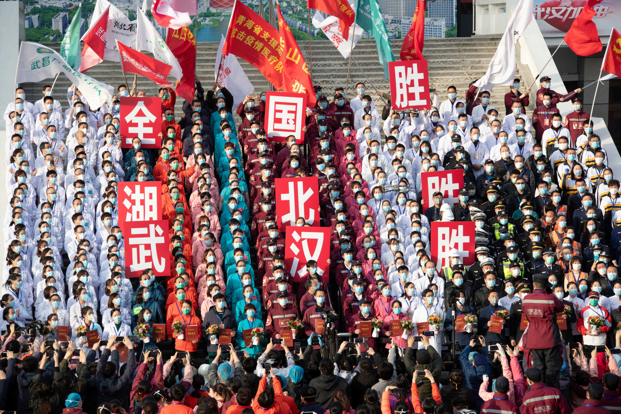 Medical workers and security personnel wearing face masks attend a ceremony marking the closure of the last makeshift hospital in Wuhan, the epicentre of the novel coronavirus outbreak, following the discharge of its last batch of coronavirus patients, in Hubei province, China March 10, 2020. The Chinese characters on the placards read, "Victory of the country, victory of Hubei, victory of Wuhan". Picture taken March 10, 2020. cnsphoto via REUTERS. ATTENTION EDITORS - THIS IMAGE WAS PROVIDED BY A THIRD PARTY. CHINA OUT.