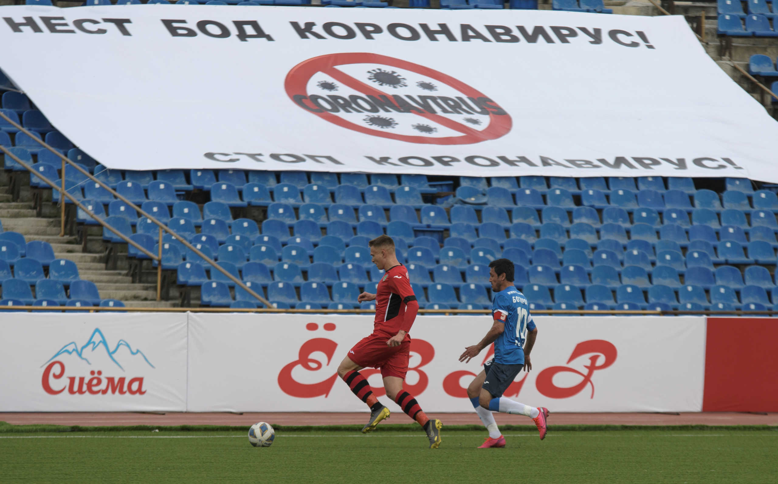 Soccer Football - Super Cup - FC Istiklol Dushanbe v FC Khujand - Dushanbe, Tajikistan April 4, 2020. Players take part in the match, as soccer competitions in Tajikistan continue despite the global coronavirus (COVID-19) outbreak. The banner (bottom) reads: "Stop coronavirus!"  REUTERS