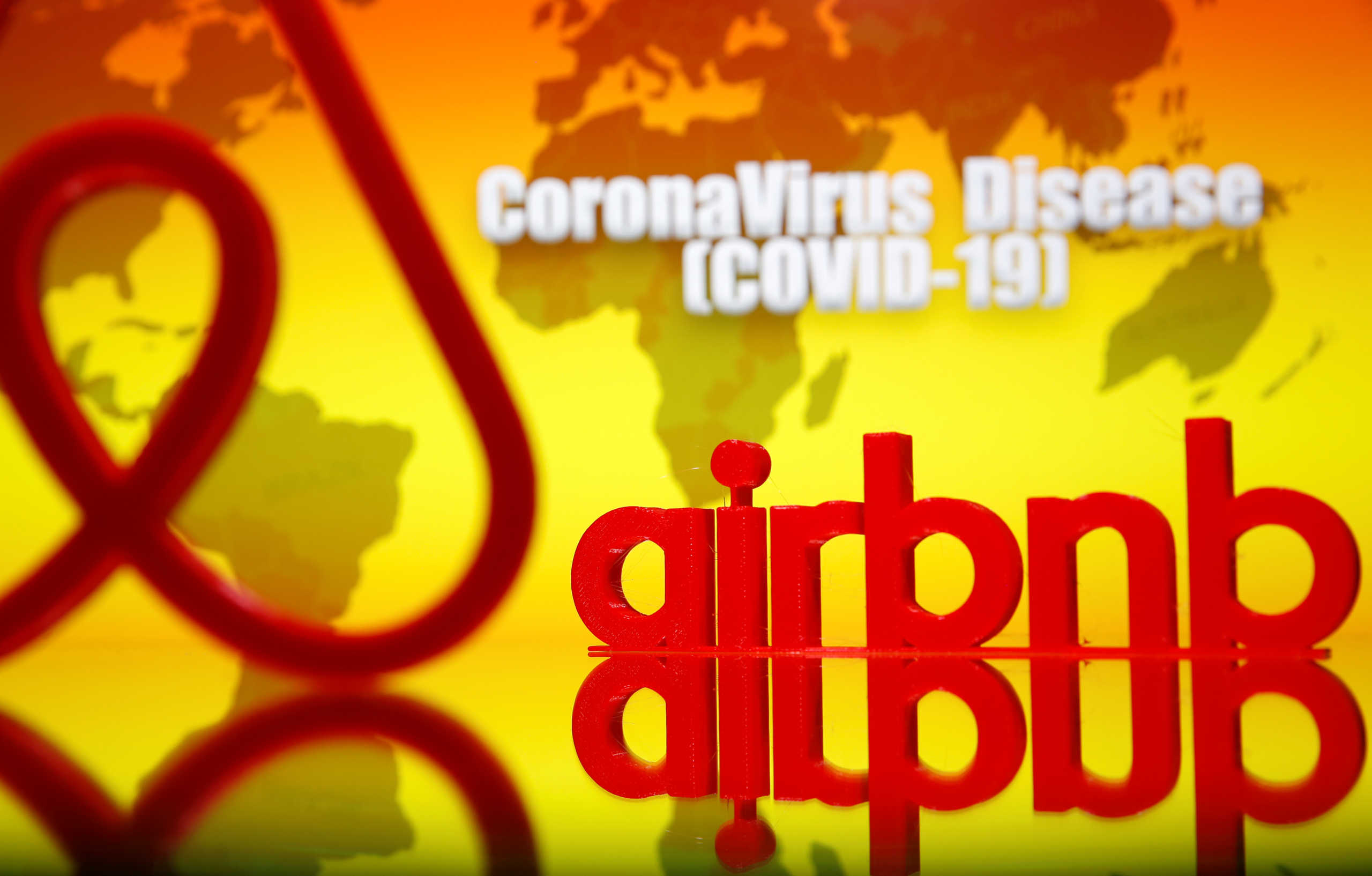 A 3D printed Airbnb logo is seen in front of displayed coronavirus disease (COVID-19) writing in this illustration taken, March 23, 2020. Picture taken March 23, 2020. REUTERS