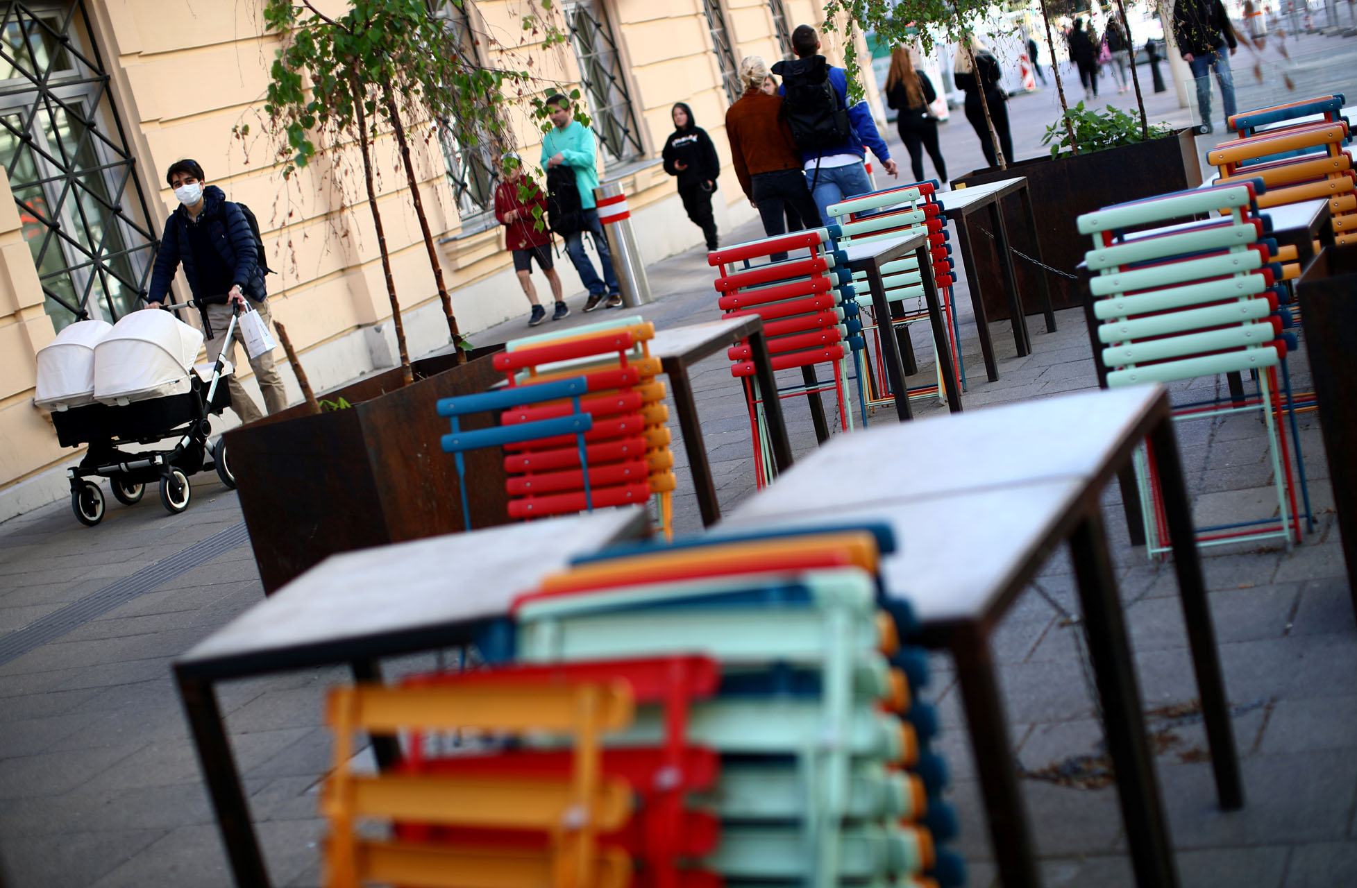 People walk past abandoned tables of a closed restaurant during the global coronavirus disease (COVID-19) outbreak in Vienna, Austria, April 20, 2020.  REUTERS