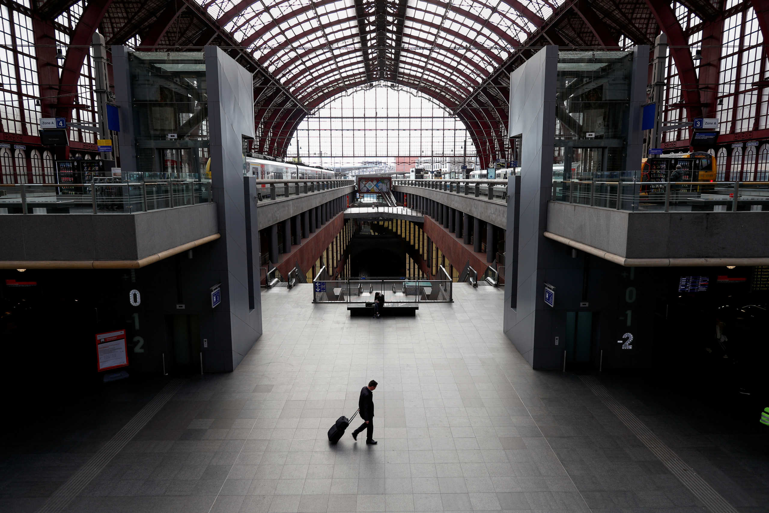 FILE PHOTO: A man walks with his luggage through the almost empty railway station, after Belgium imposed a lockdown to slow down the spread of the coronavirus disease (COVID-19), in Antwerp, Belgium March 18, 2020.  REUTERS