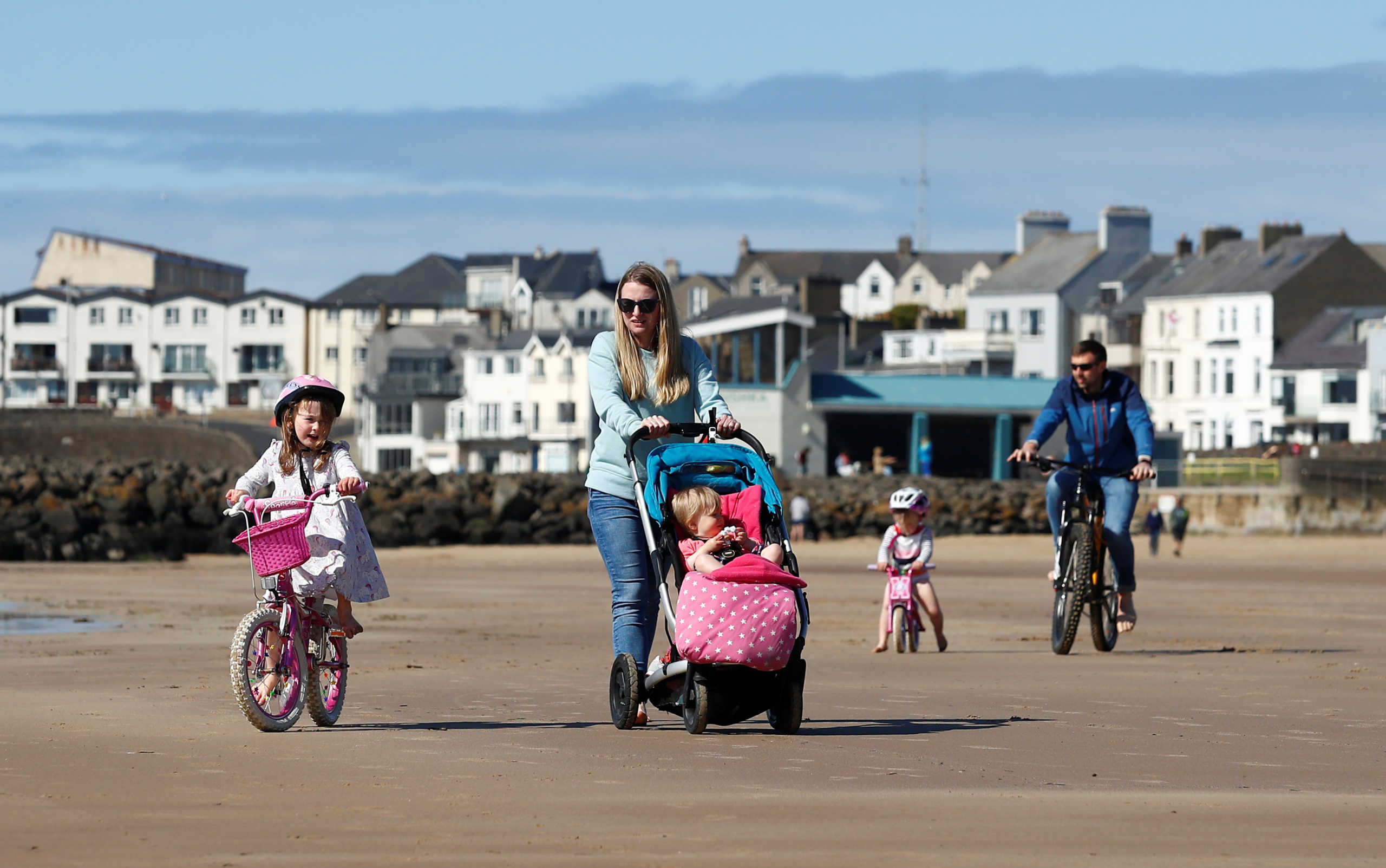 Phil and Laura Gray along with their children, Sofia 5, Bella 3 and Connie 1 exercise on the beach in Portrush, following the outbreak of the coronavirus disease (COVID-19), Portrush, Northern Ireland, April 26, 2020. REUTERS