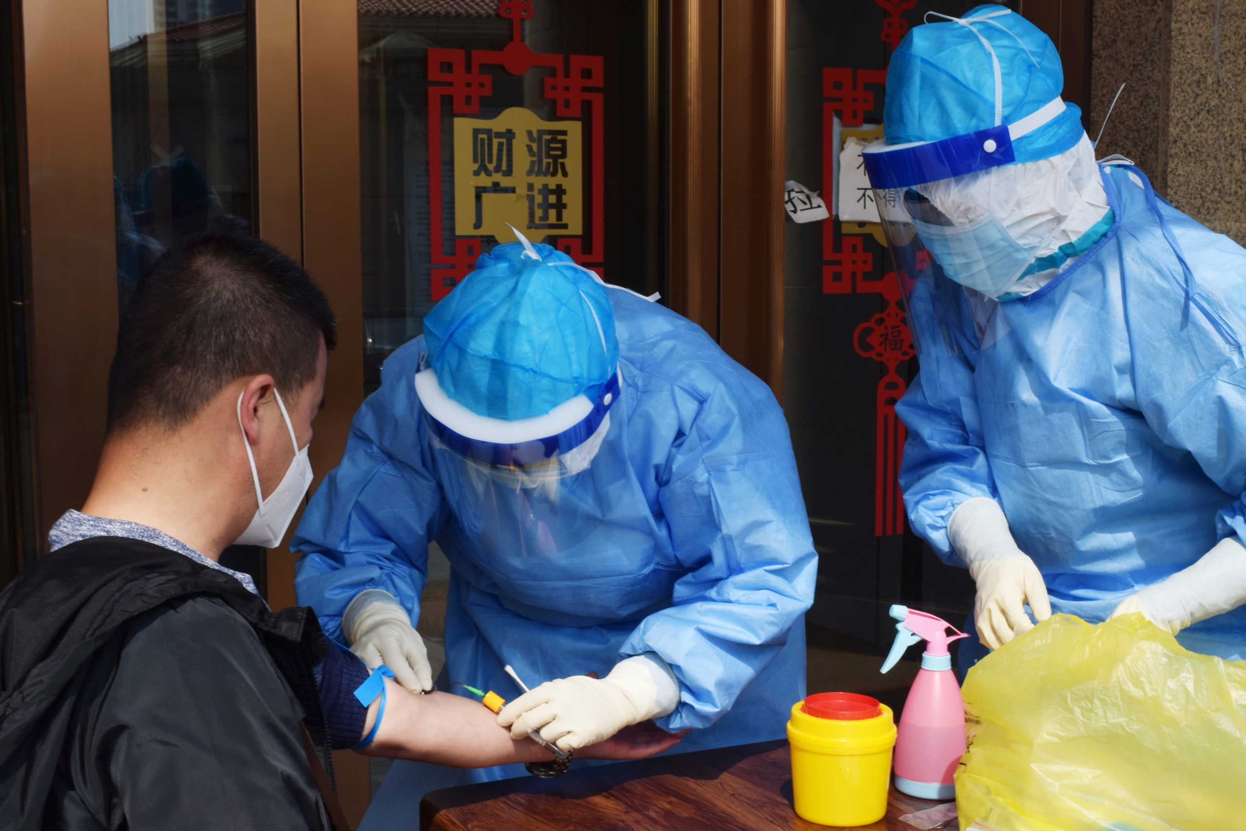 A worker from the city's center for disease control and prevention draws blood from a man to conduct a test for antibodies against the coronavirus disease (COVID-19) in Suifenhe, a city bordering Russia in China's Heilongjiang province, April 16, 2020. REUTERS
