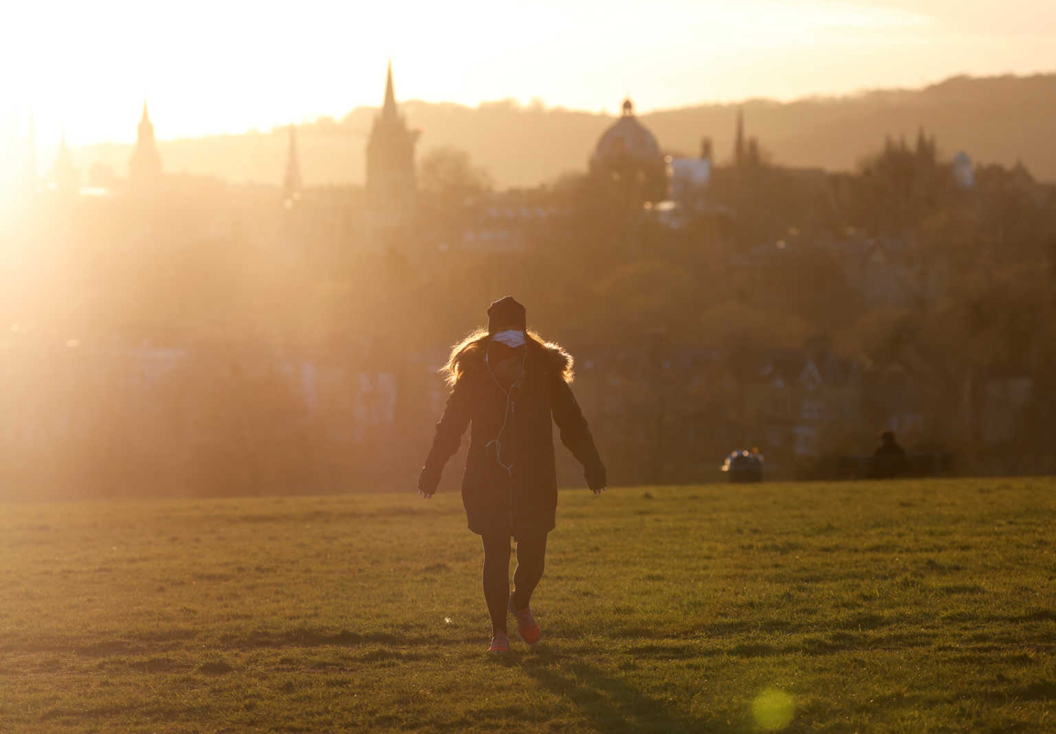 A woman wearing her protective face mask is seen during the sunset as the spread of the coronavirus disease (COVID-19) continues, Oxford, Britain, March 31, 2020. REUTERS