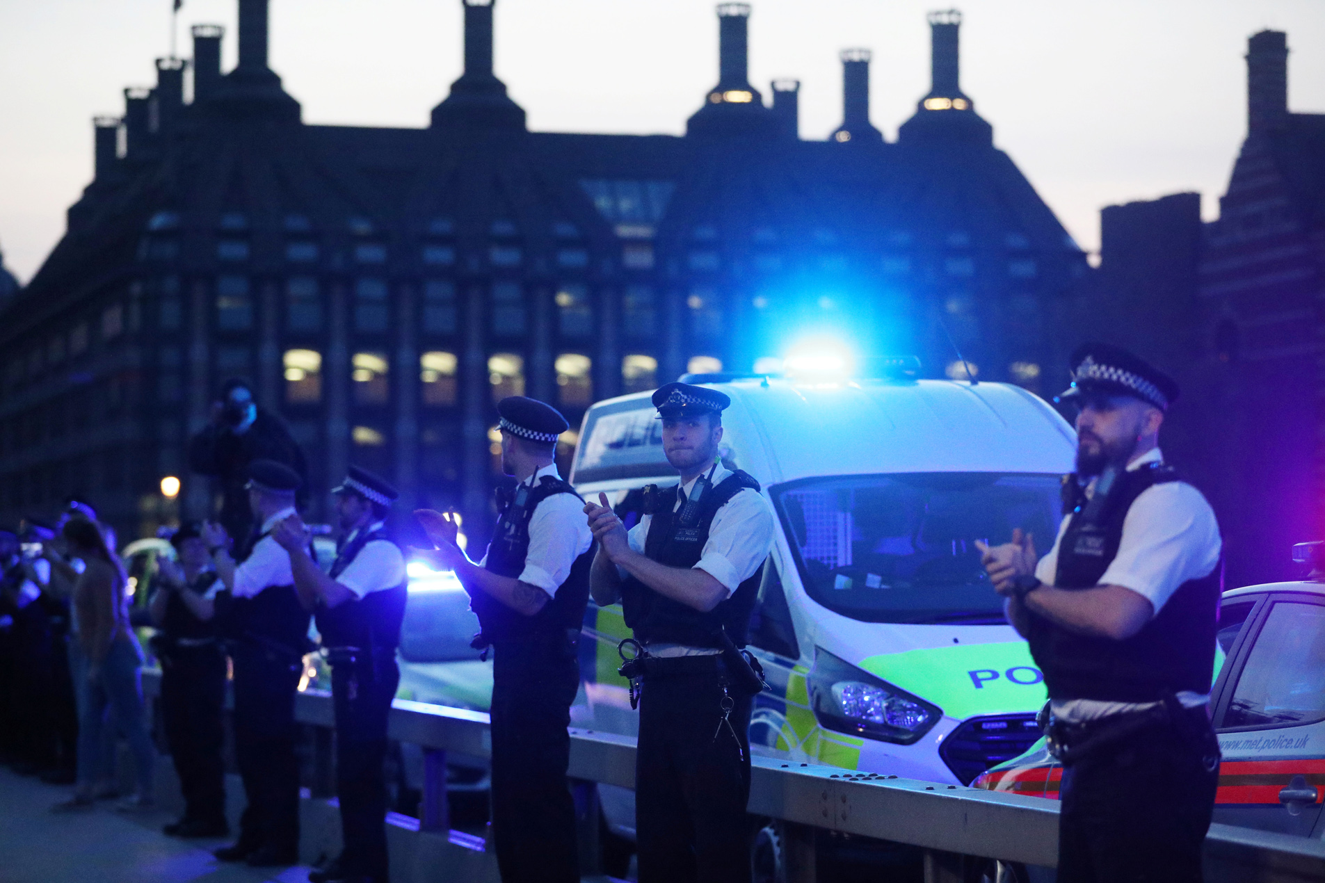 Police officers applaud on Westminster bridge during the Clap for our Carers campaign in support of the NHS as the spread of the coronavirus disease (COVID-19) continues, London, Britain, April 9, 2020. REUTERS