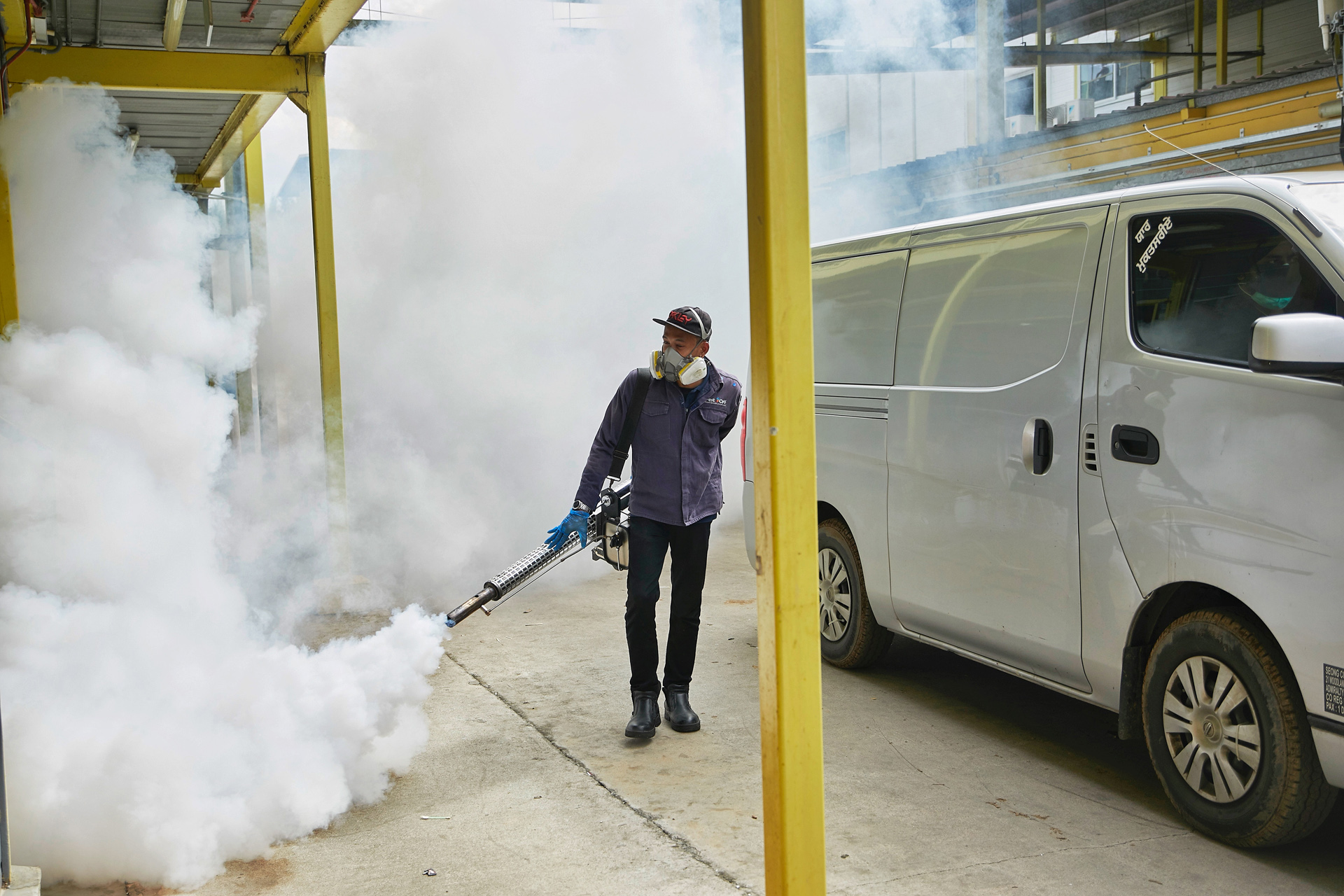 A man wearing a protective face mask fumigates outside of S11 Punggol dormitory, as the outbreak of the coronavirus disease (COVID-19) continues, in Singapore April 7, 2020. Picture taken April 7, 2020. Ministry of Manpower Singapore