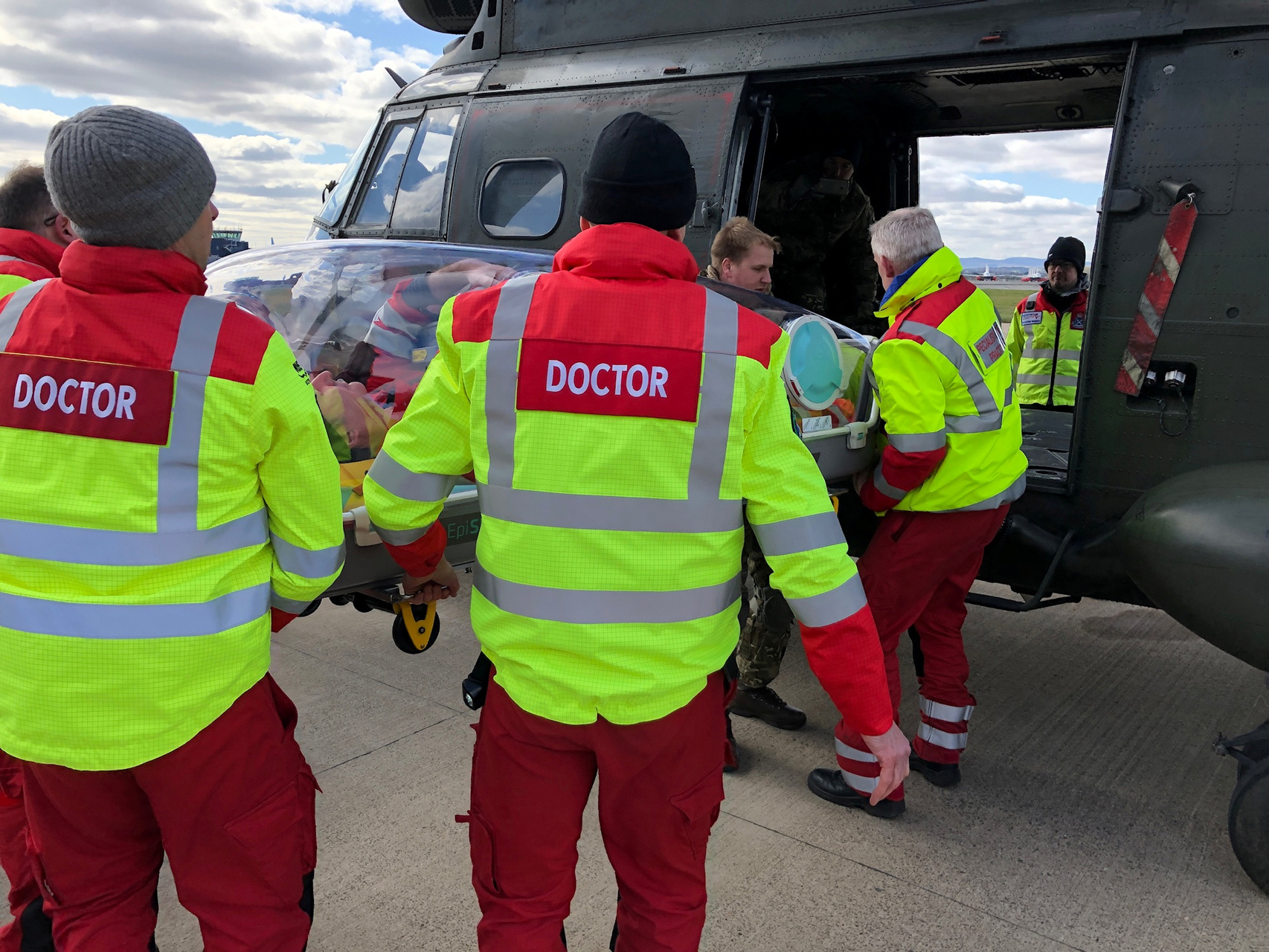 A Puma crewman demonstrates to the doctors and paramedics of the Scottish Ambulance Service how the EpiShuttle can be loaded through the side door on the helicopter, in Moray Firth, Scotland, Britain March 29, 2020. Ministry of Defence
