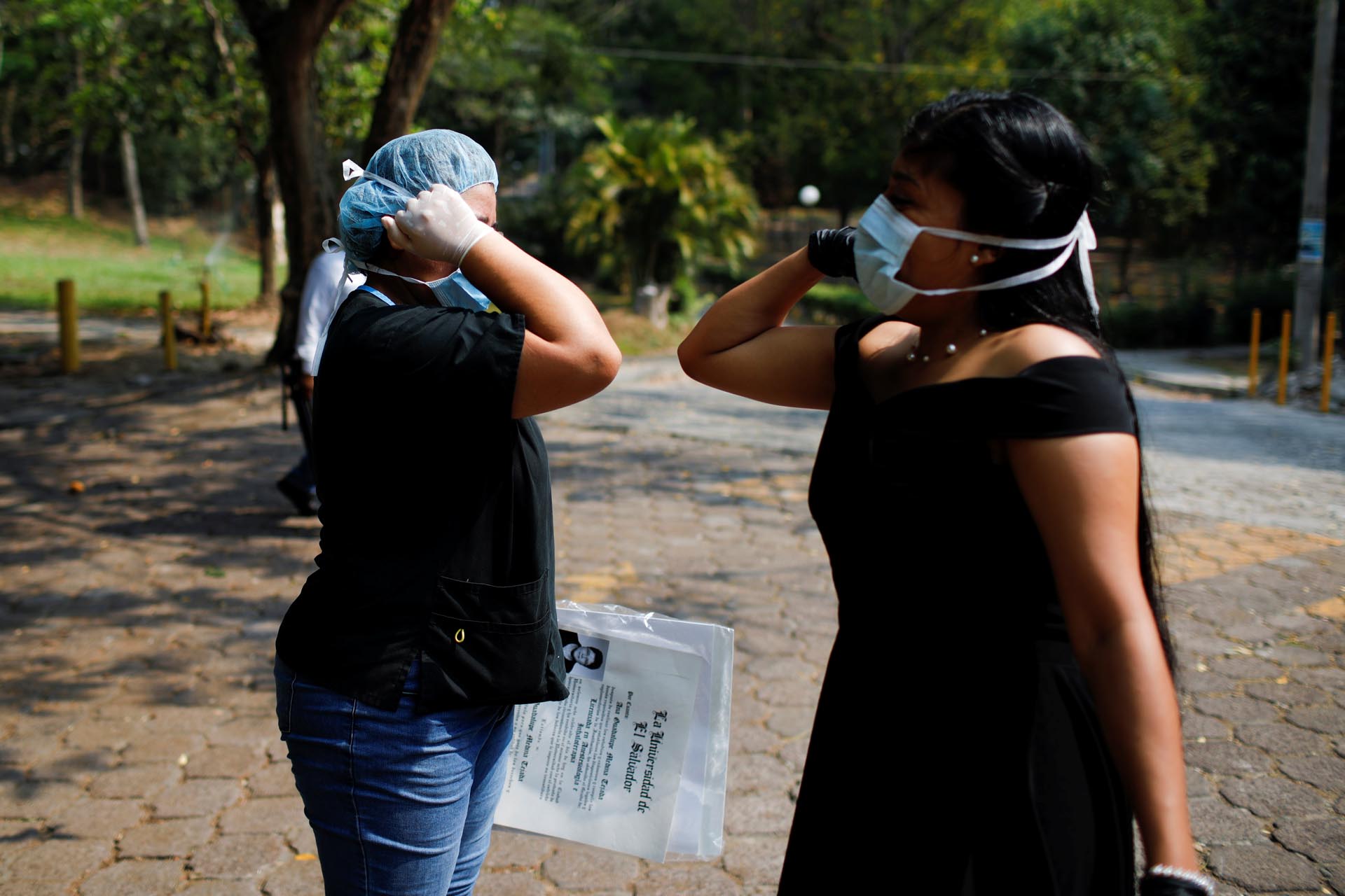 Students greet each other as they pick up their doctor's titles at El Salvador National University (UES) after the graduation ceremony was suspended during a quarantine throughout the country, as the government undertakes steadily stricter measures to prevent the spread of the coronavirus disease (COVID-19), in San Salvador, El Salvador April 6, 2020. REUTERS