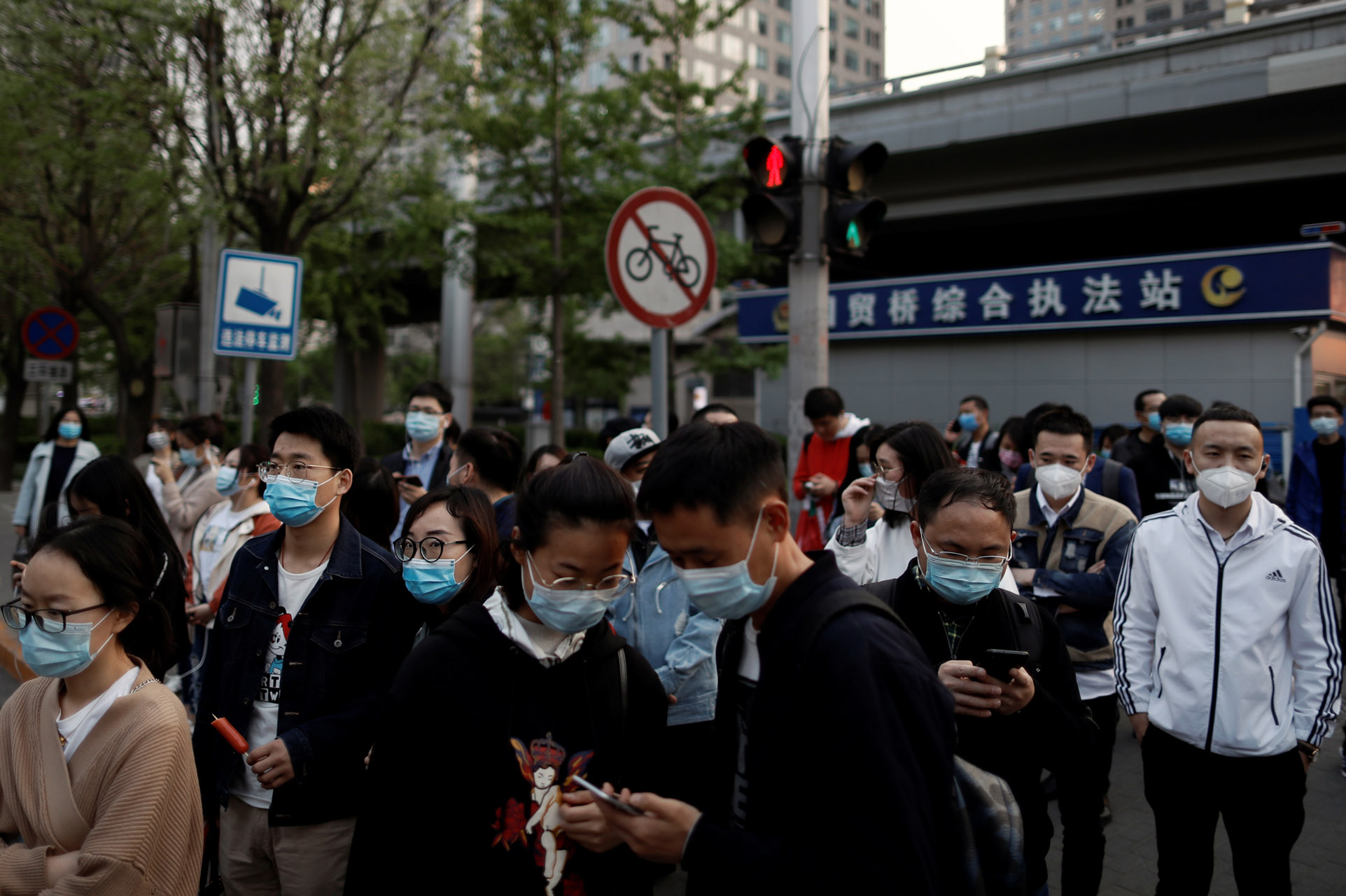 People wearing protective face masks leave work after office hours in Central Business District, as the spread of the new coronavirus disease (COVID-19) continues, in Beijing, China, April 17, 2020. REUTERS