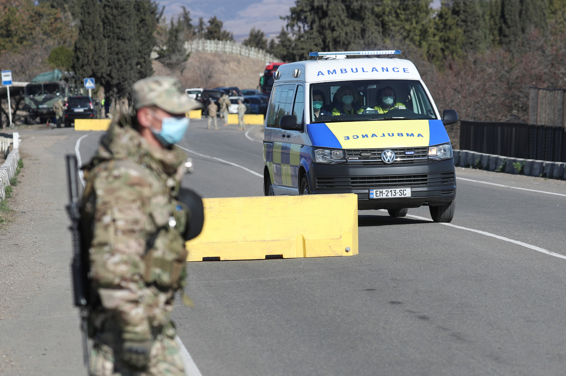 A Georgian serviceman wearing a protective mask stands guard as an ambulance drives through a check point, after authorities tightened up measures to prevent the spread of coronavirus disease (COVID-19), in Marneuli near Tbilisi, Georgia March 23, 2020. REUTERS