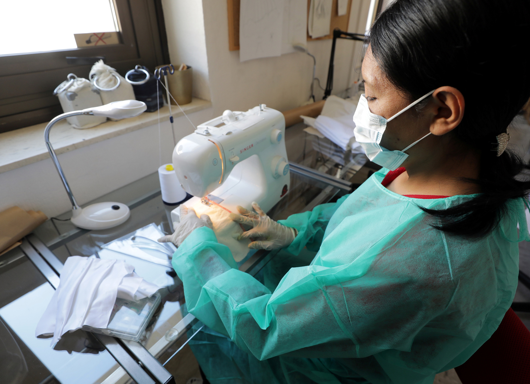 French seamstress Jennyfer Flores sews a protective face mask at Aline Buffet's sewing workshop in Cannes, as the spread of the coronavirus disease continues in France, April 8, 2020.   REUTERS