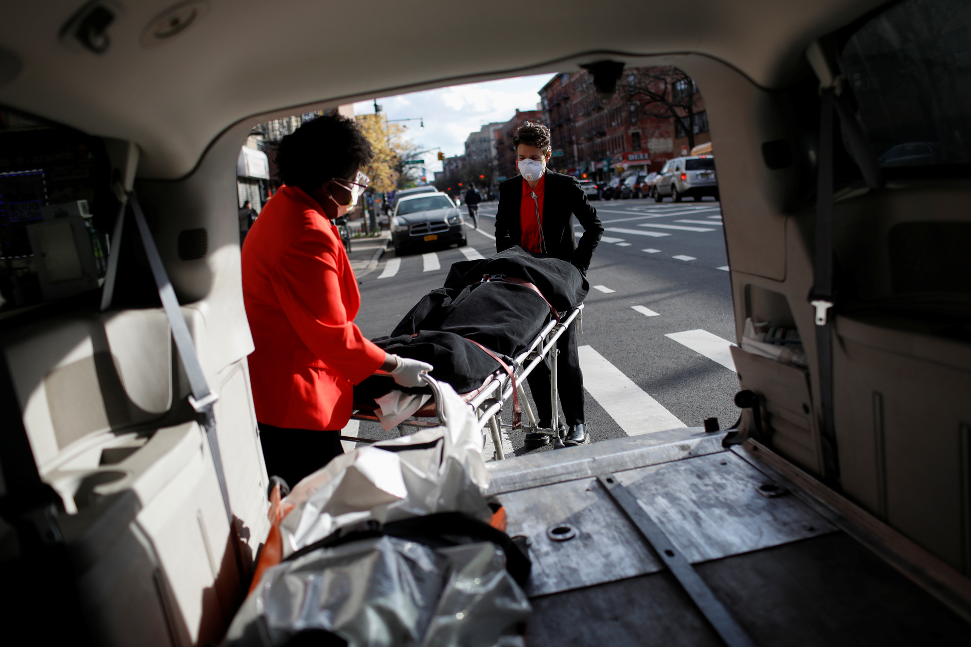 Nicole Warring, 33, and Lily Sage Weinrieb, 25, both of whom are Resident Funeral Directors at International Funeral & Cremation Services, a funeral home in Harlem, remove a deceased person from a funeral service vehicle, during the coronavirus disease (COVID-19) outbreak, in Manhattan, New York City, New York, U.S., April 16, 2020. REUTERS