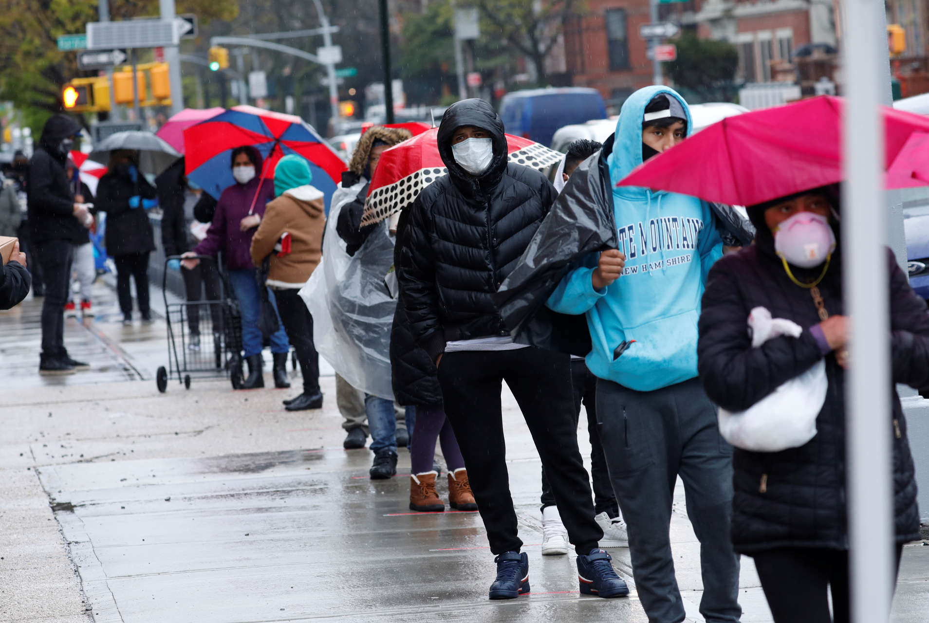 People wear protective face masks as they wait in line to receive free food at a curbside pantry for needy residents run by the Catholic Charities of Brooklyn and Queens during the outbreak of the coronavirus disease (COVID-19) in the Brooklyn borough of New York City, New York, U.S., April 24, 2020. REUTERS