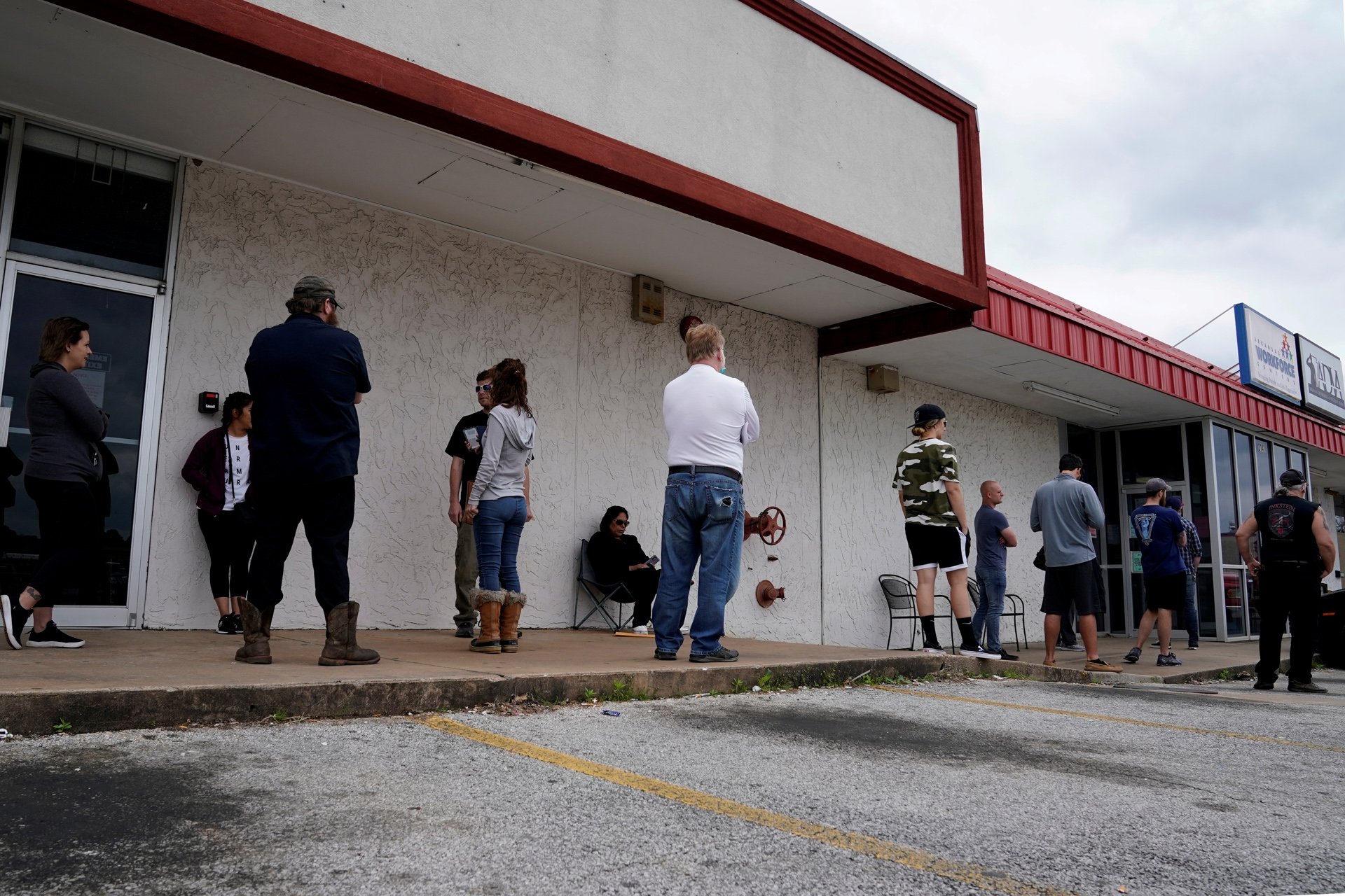 FILE PHOTO: People who lost their jobs wait in line to file for unemployment following an outbreak of the coronavirus disease (COVID-19), at an Arkansas Workforce Center in Fayetteville, Arkansas, U.S. April 6, 2020. REUTERS