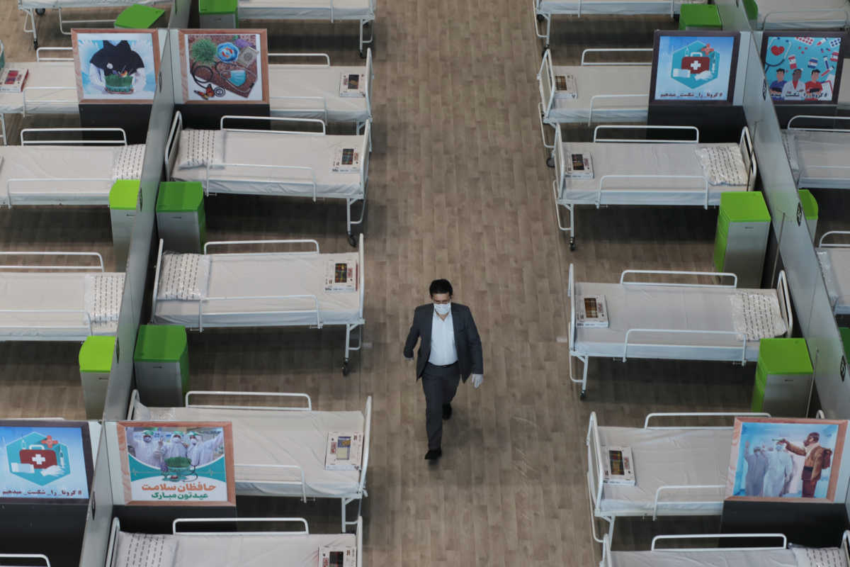 A man walks between beds at a shopping mall, one of Iran's largest, which has been turned into a centre to receive patients suffering from the coronavirus disease (COVID-19), in Tehran, Iran, April 4, 2020. WANA (West Asia News Agency)