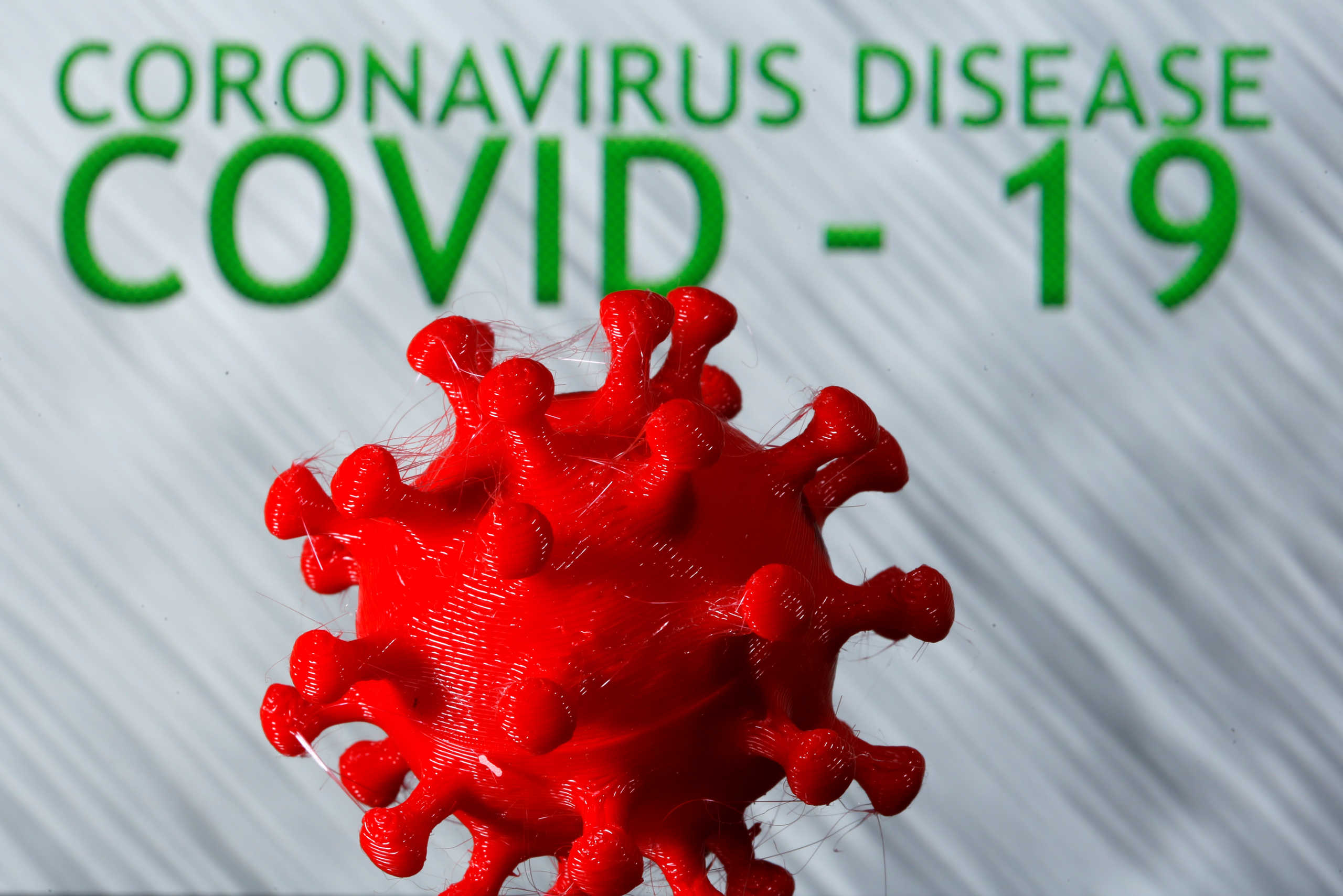 A 3D-printed coronavirus model is seen in front of the words coronavirus disease (Covid-19) on display in this illustration taken March 25, 2020. REUTERS