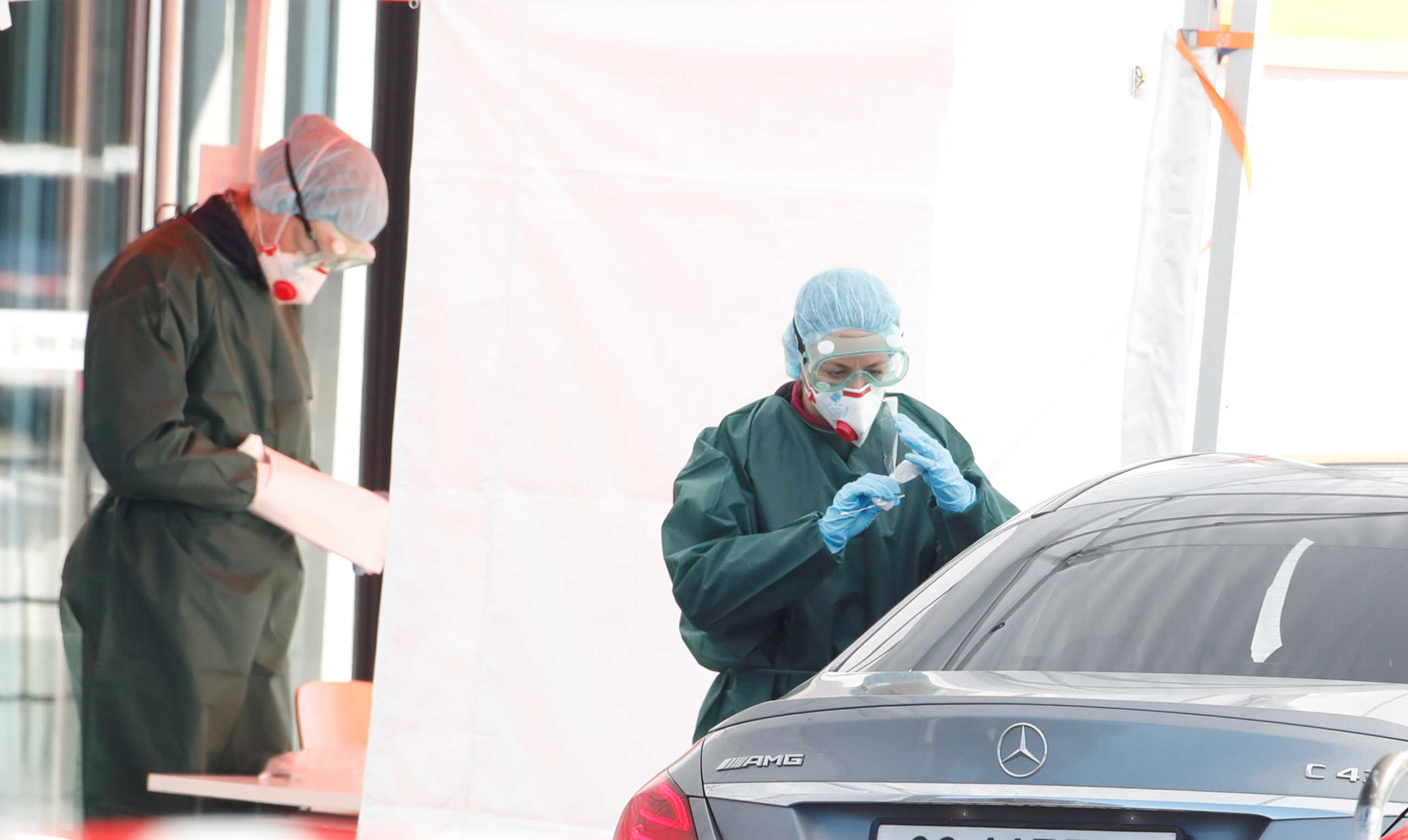 A health worker takes a test from a person in a car at a drive-in test center for tests on coronavirus disease (COVID-19) in Luzern, Switzerland March 31, 2020. REUTERS