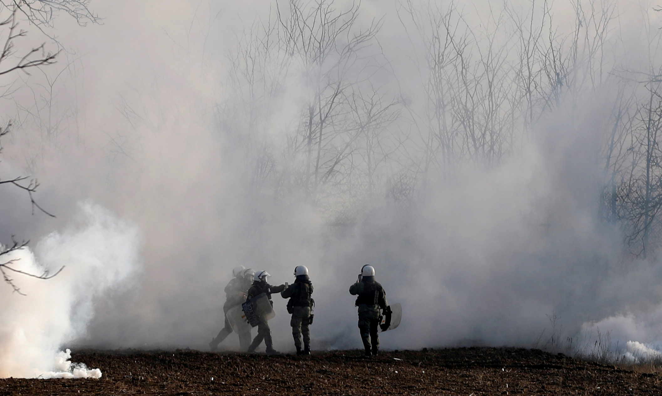 FILE PHOTO: Greek riot police officers stand amid clouds of tear gas near Turkey's Pazarkule border crossing, in Kastanies, Greece March 6, 2020. Picture taken March 6, 2020. REUTERS