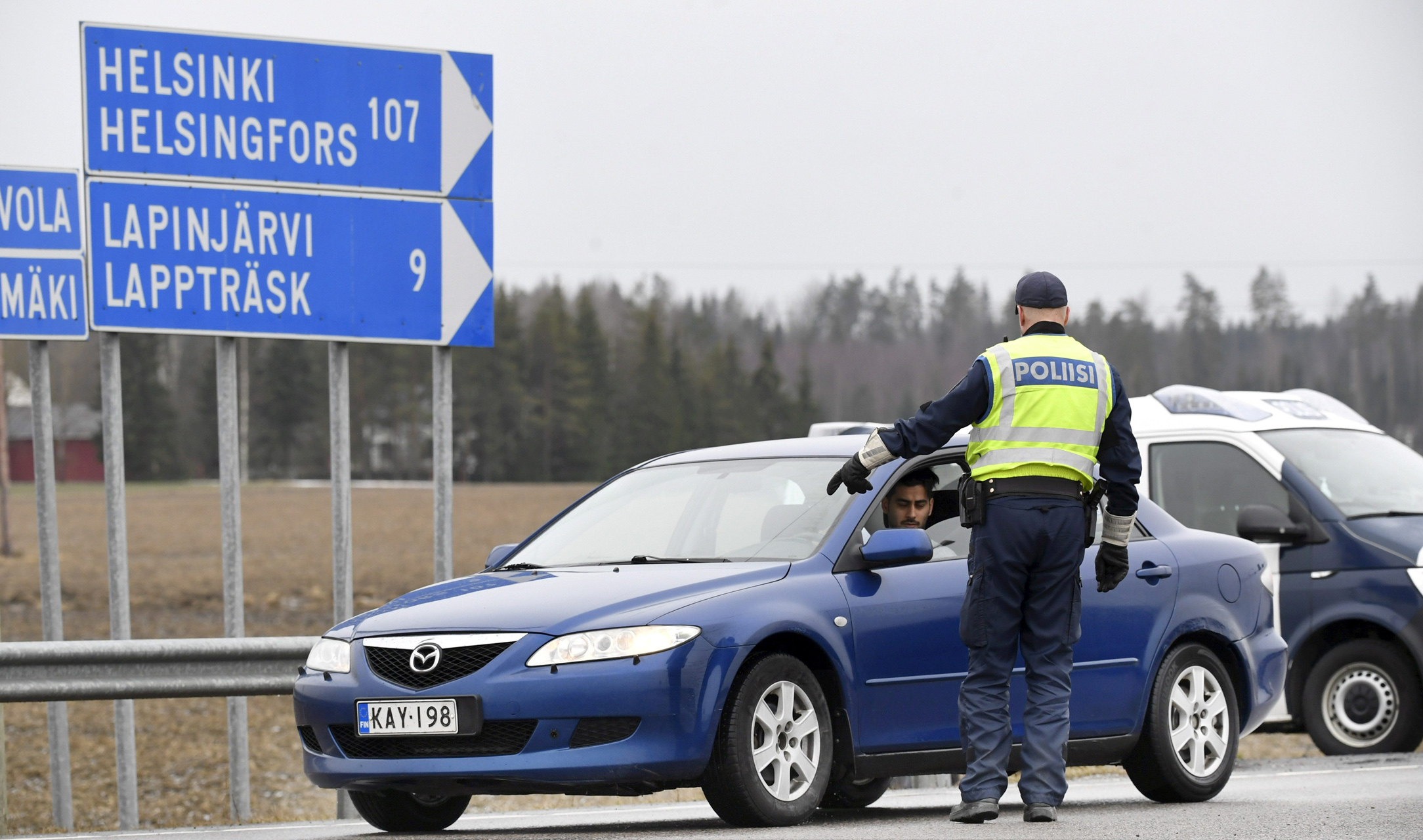 A police officer stops a vehicle for a document check at a traffic control post, as roadblocks were setup on all routes that connect Helsinki with the rest of the country to prevent the spread of the coronavirus disease (COVID-19), in Lapinjarvi, Finland April 6, 2020. Heikki Saukkomaa