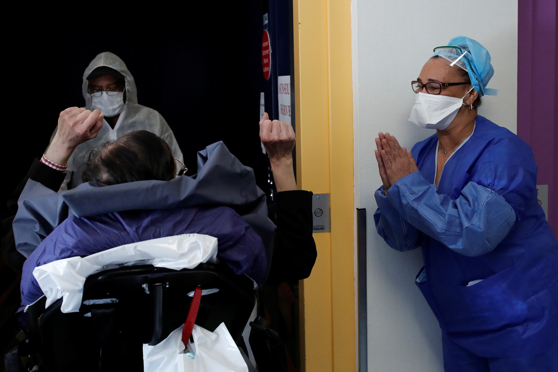Medical staff member applauds patient Mang Phother, 61, who spent 16 days in the Intensive Care Unit (ICU) for the coronavirus disease (COVID-19), as he leaves the Clinique de l'Estree private hospital in Stains near Paris as the spread of the coronavirus disease continues in France, April 23, 2020.   REUTERS