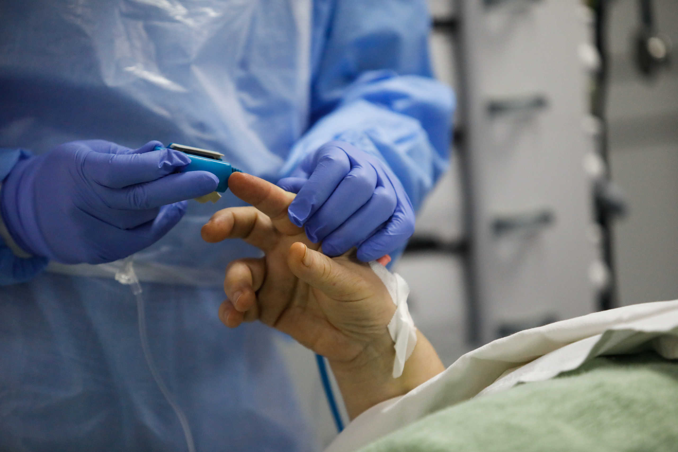 A medical worker applies a pulse oximeter on a patient at the intensive care unit (ICU) of the Sotiria hospital, following the coronavirus disease (COVID-19) outbreak, in Athens, Greece, April 22, 2020. REUTERS