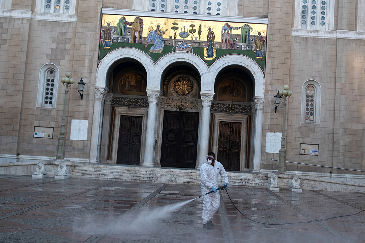 A municipal worker wearing personal protective equipment (PPE) disinfects the area around the Athens' Metropolitan Cathedral, during the coronavirus disease (COVID-19) outbreak ahead of the Greek Orthodox Easter, in Athens, Greece, April 17, 2020. REUTERS