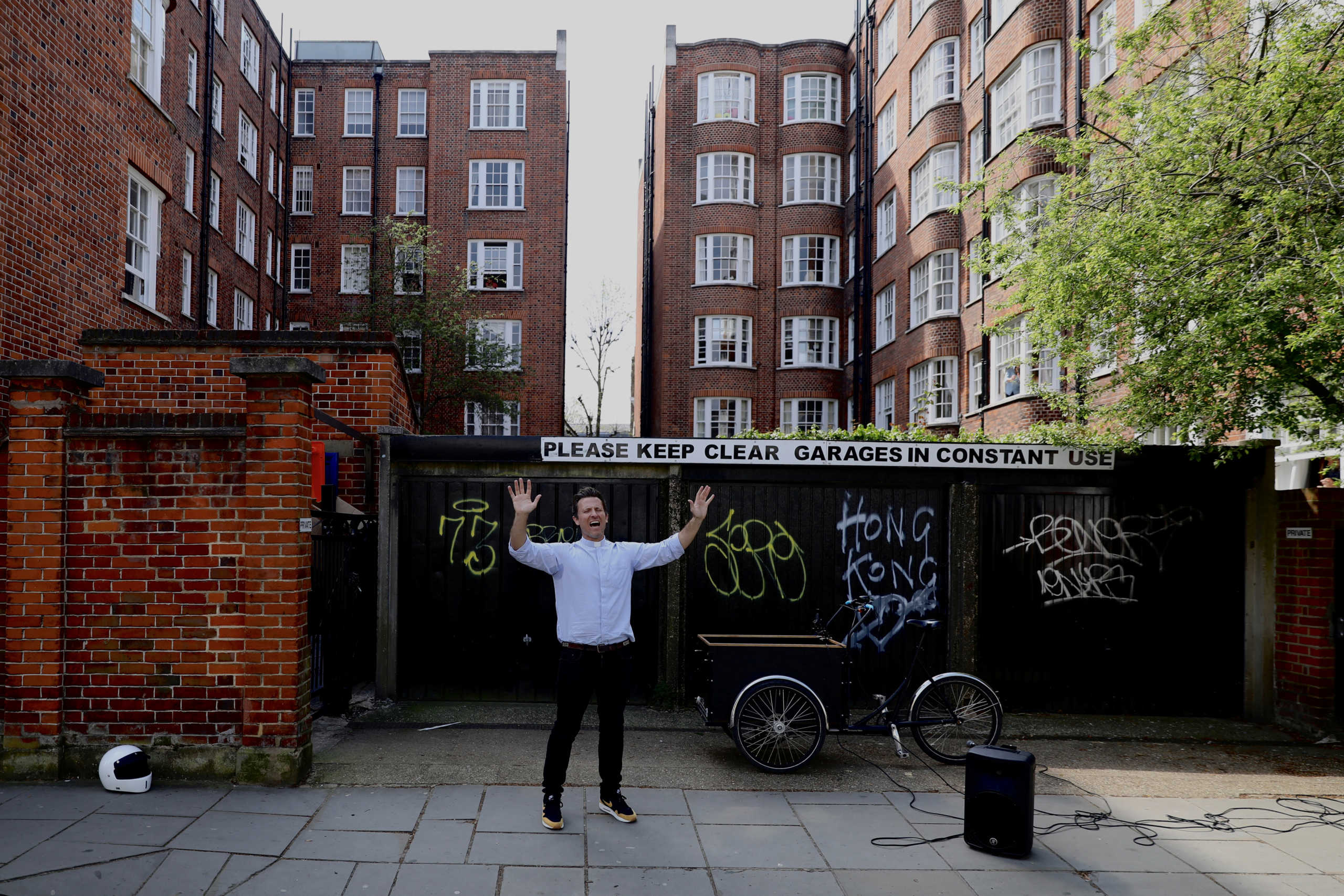 The Reverend Pat Allerton, a vicar at St Peters church in Notting Hill, leads prayer on Portobello Road on Easter Sunday, as the spread of the coronavirus disease (COVID-19) continues, in London, Britain, April 12, 2020.  REUTERS