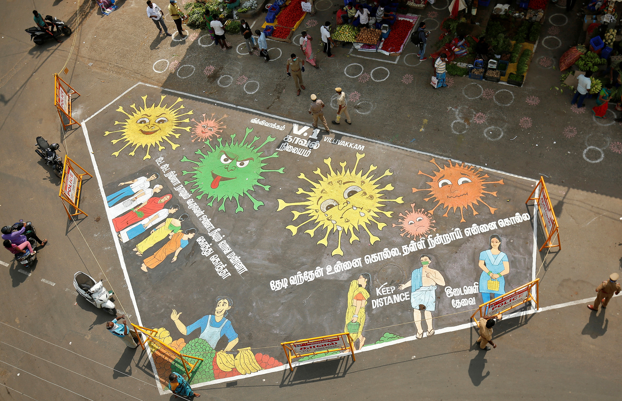 Police officers stand around a graffiti on a road depicting coronavirus to create awareness about social distancing during a 21-day nationwide lockdown to slow the spreading of coronavirus disease (COVID-19), in Chennai, India, April 9, 2020. REUTERS