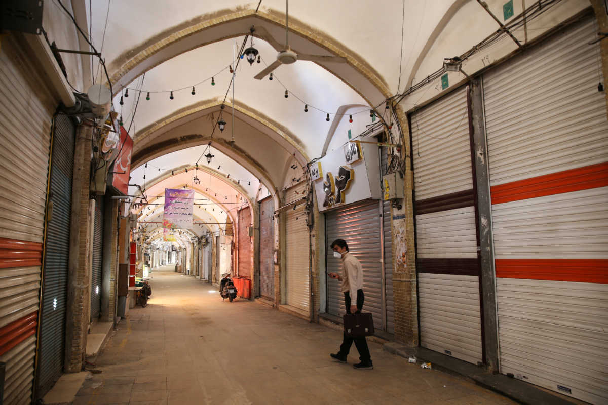 A man wearing a protective face mask, following the outbreak of coronavirus disease (COVID-19), walks next to closed shops in Qom, Iran March 24, 2020. Picture taken March 24, 2020. WANA (West Asia News Agency) via REUTERS ATTENTION EDITORS - THIS PICTURE WAS PROVIDED BY A THIRD PARTY