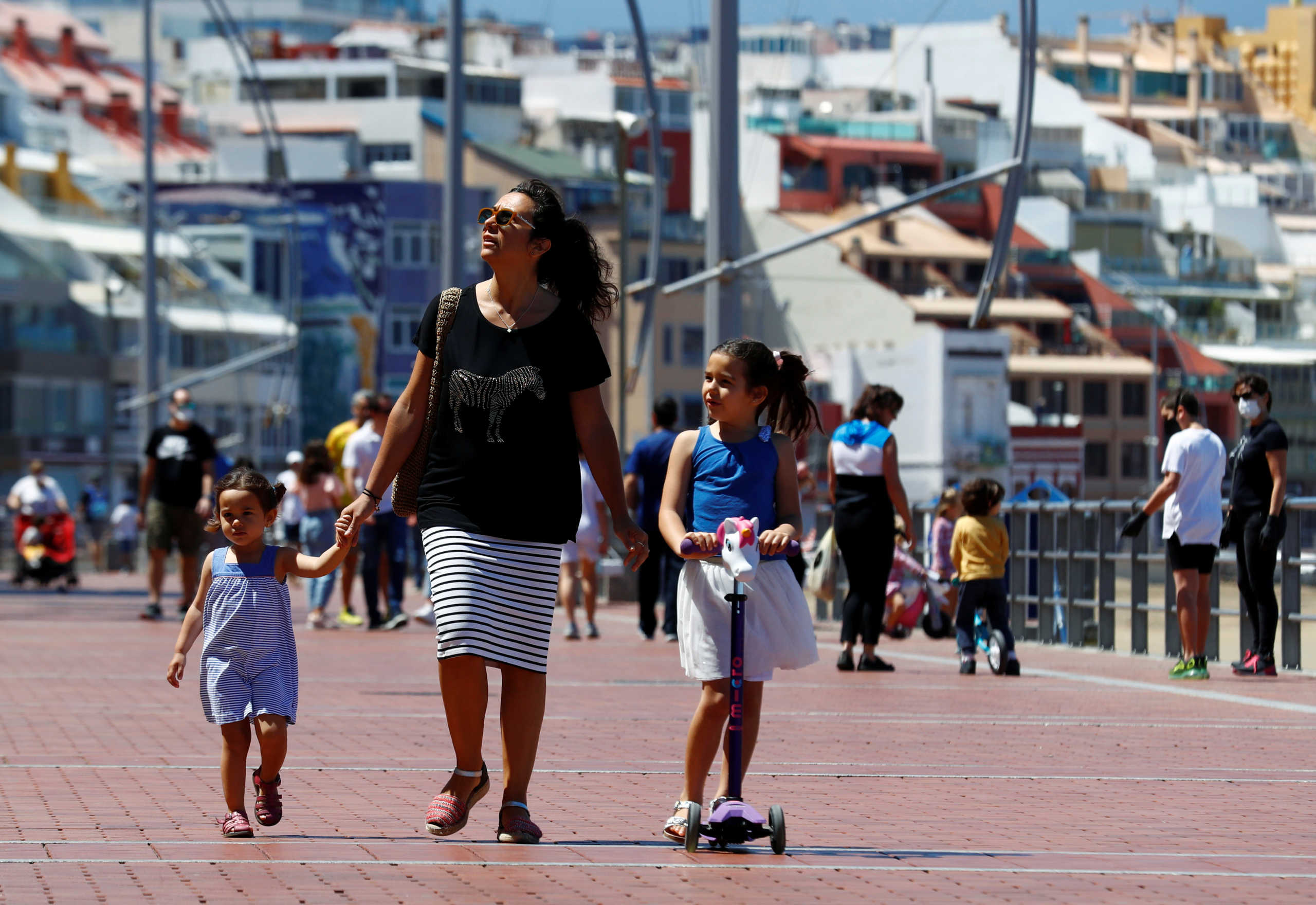 Family members walk at promenade of Las Canteras beach after restrictions were partially lifted for children for the first time in six weeks, following the coronavirus disease (COVID-19) outbreak on the island of Gran Canaria, Spain, April 26, 2020. REUTERS