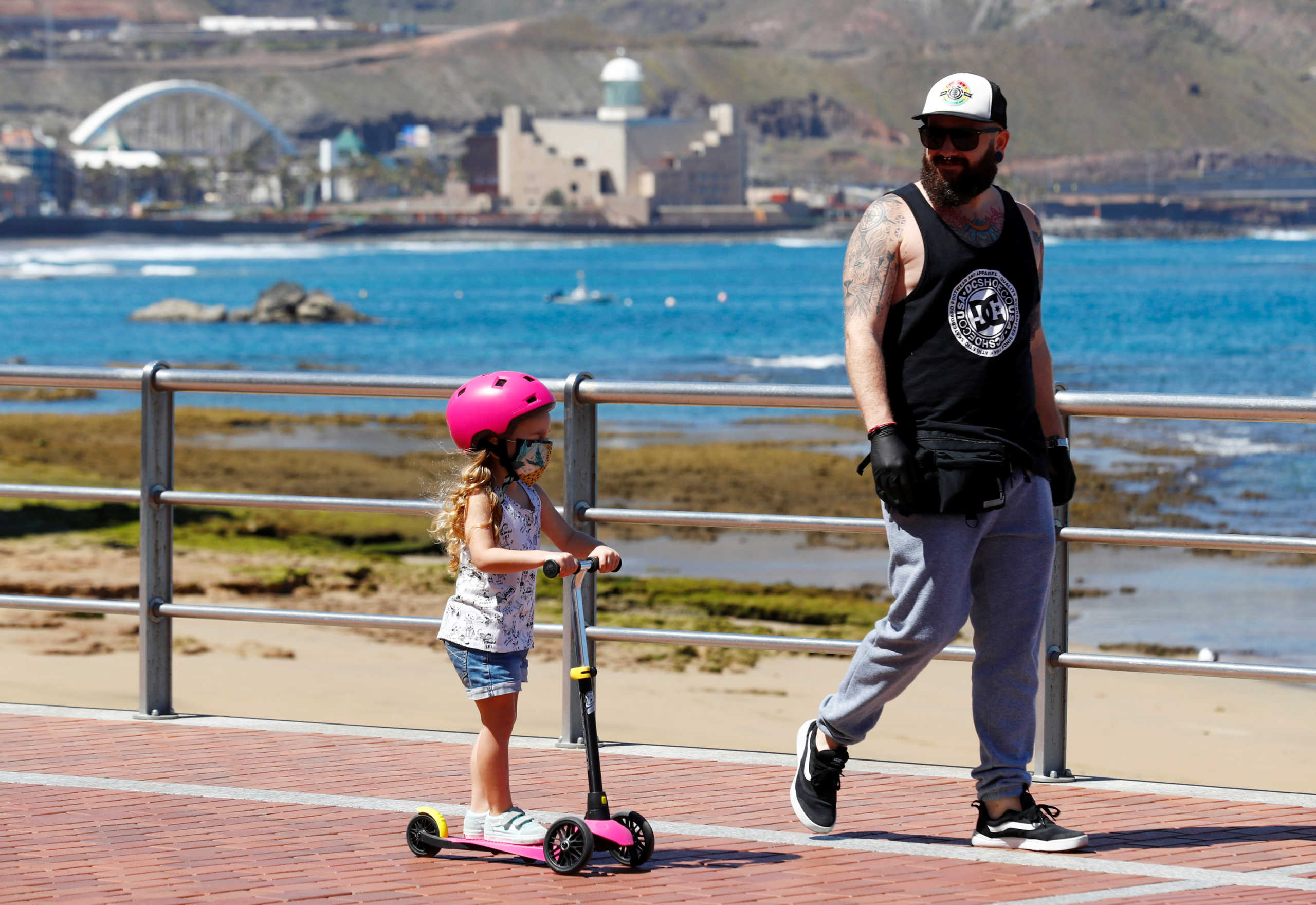 Family members walk at promenade of Las Canteras beach after restrictions were partially lifted for children for the first time in six weeks, following the coronavirus disease (COVID-19) outbreak on the island of Gran Canaria, Spain, April 26, 2020. REUTERS