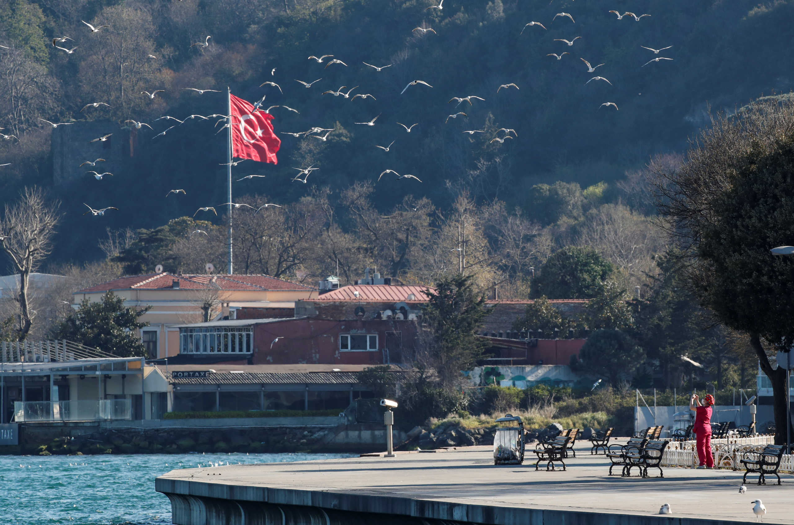 A woman takes a picture of seagulls during a two-day curfew which was imposed to prevent the spread of the coronavirus disease (COVID-19), in Istanbul, Turkey, April 12, 2020. REUTERS