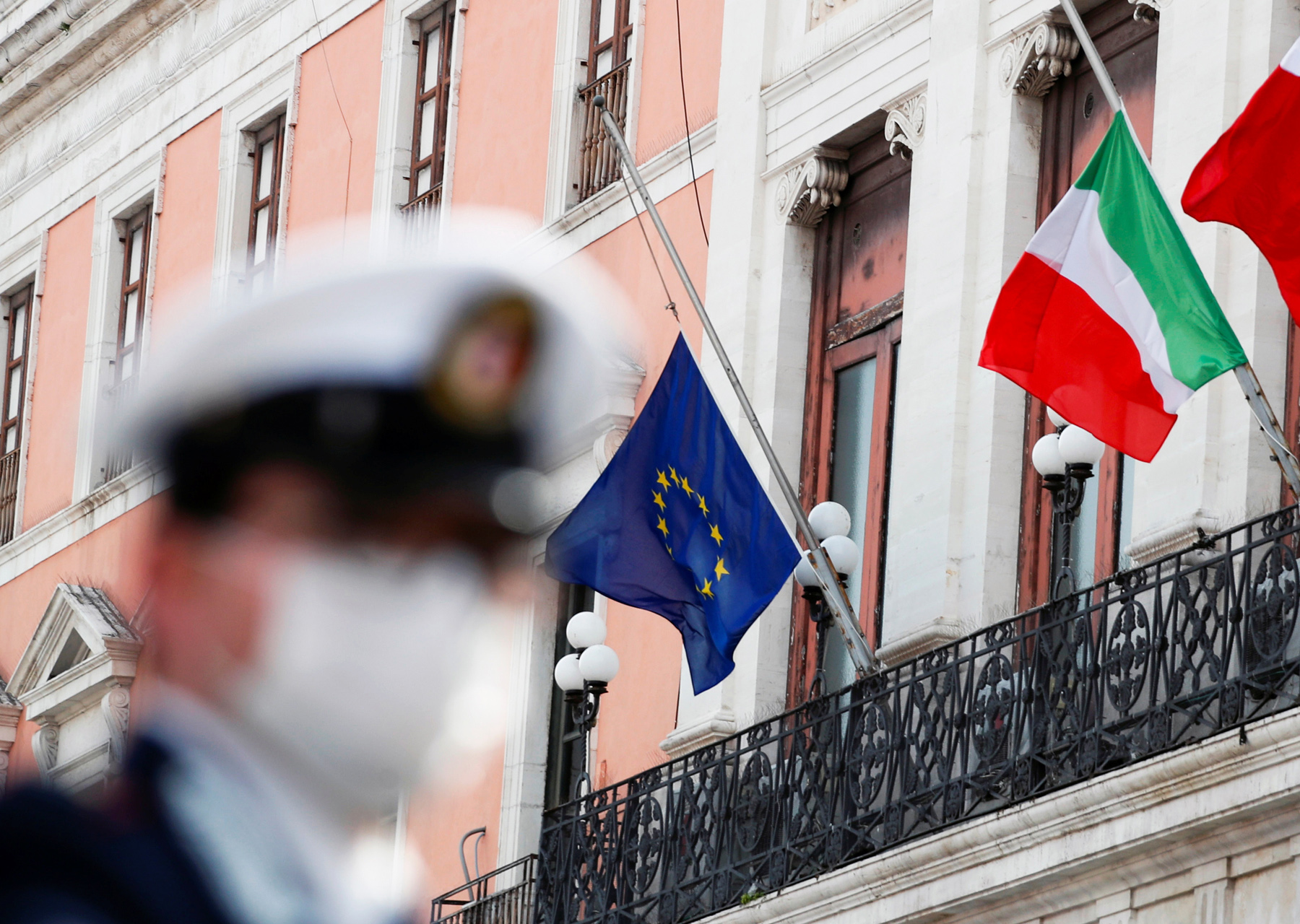 The flags of Italy, the European Union and Bari flutter to half mast to honour the country's dead due to coronavirus disease (COVID-19), in Bari, Italy, March 31, 2020. REUTERS