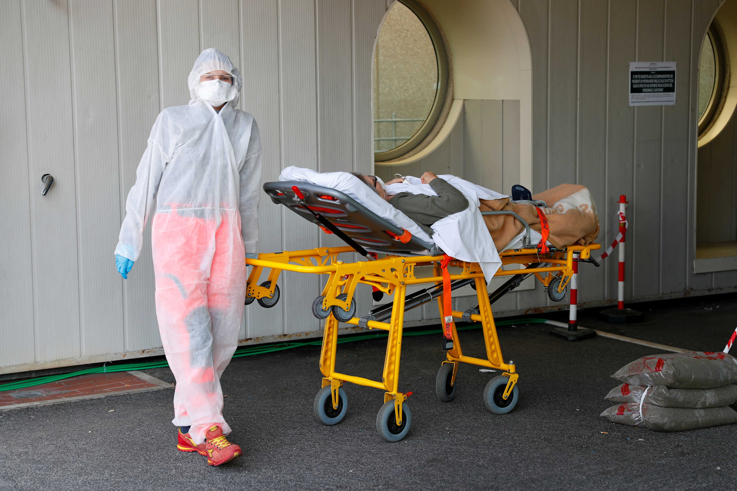 A medical worker in a protective suit carries a patient on a stretcher as they arrive at the Policlinico Tor Vergata hospital, where patients suffering from coronavirus disease (COVID-19) are being treated, in Rome, Italy, April 6, 2020. REUTERS