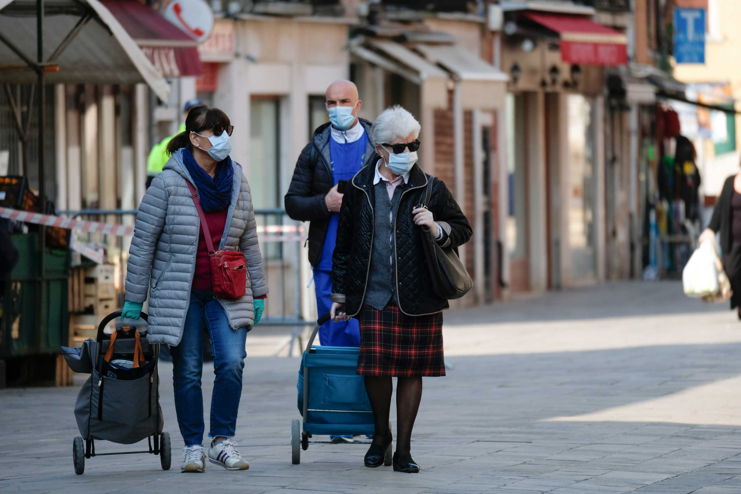 People wearing protective masks and gloves walk in the streets as the Italian government allows the reopening of some shops while a nationwide lockdown continues following the outbreak of the coronavirus disease (COVID-19), in Venice, Italy, April 14, 2020. REUTERS