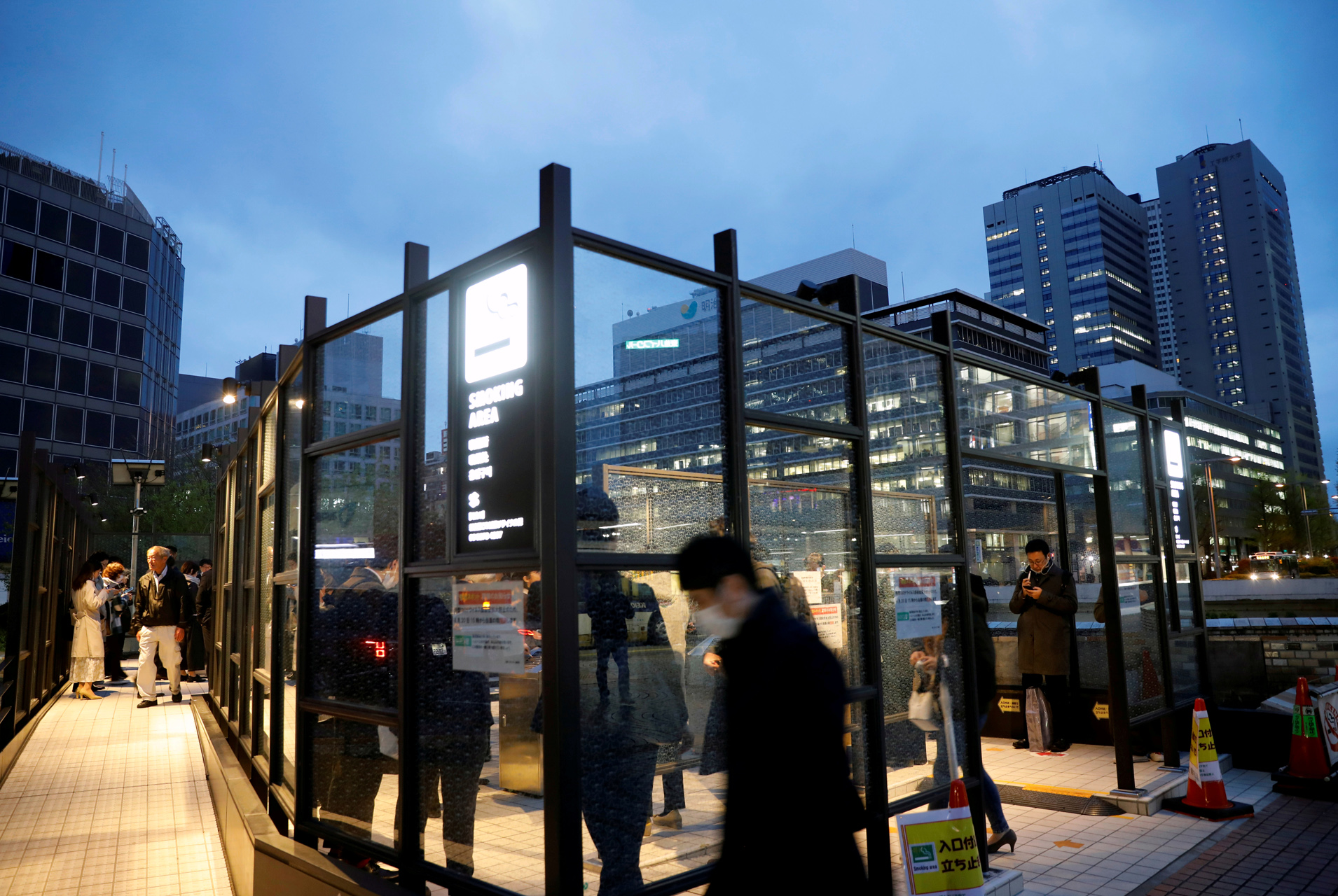 A smoking area is packed with users after the government announced the extension of the state of emergency, which had already been declared for the capital and some prefectures, to the whole country, following the coronavirus disease (COVID-19) outbreak, in Tokyo, Japan, April 17, 2020. REUTERS