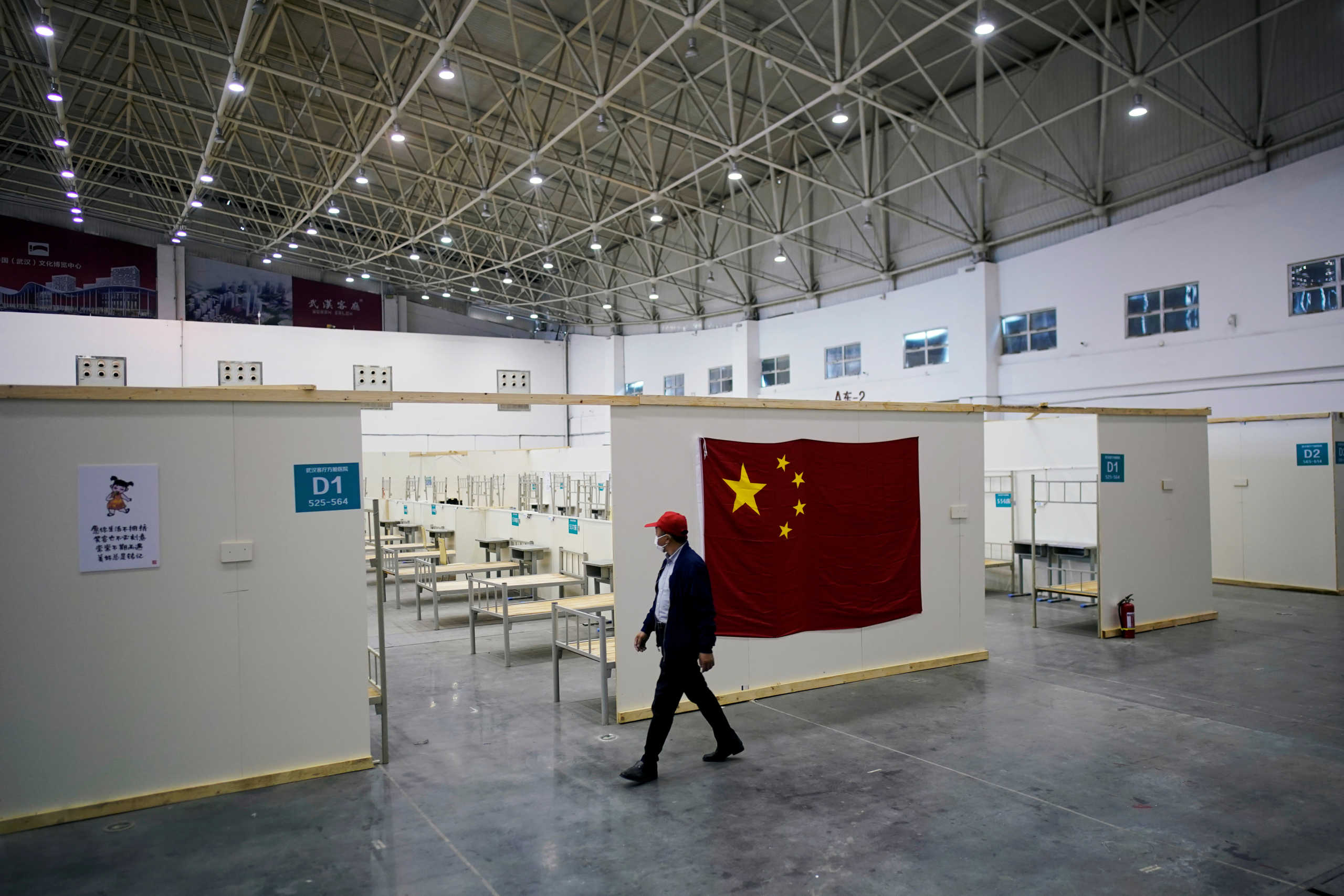 FILE PHOTO: A volunteer walks inside a convention center that was used as a makeshift hospital to treat patients with the coronavirus disease (COVID-19), in Wuhan, Hubei province, China April 9, 2020. REUTERS
