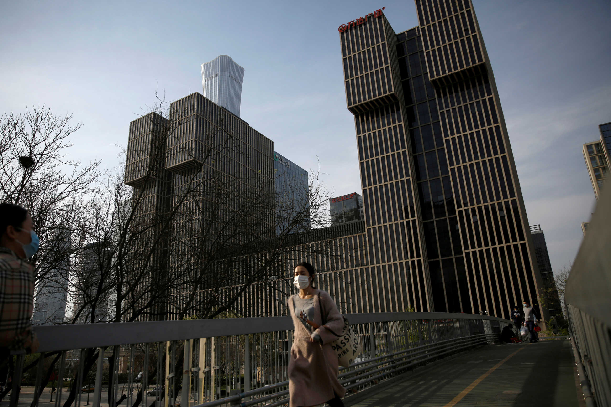 A woman wearing a face mask walks on an overpass in Beijing's central business area, amid an outbreak of the novel coronavirus disease (COVID-19) in the country, China April 5, 2020. REUTERS