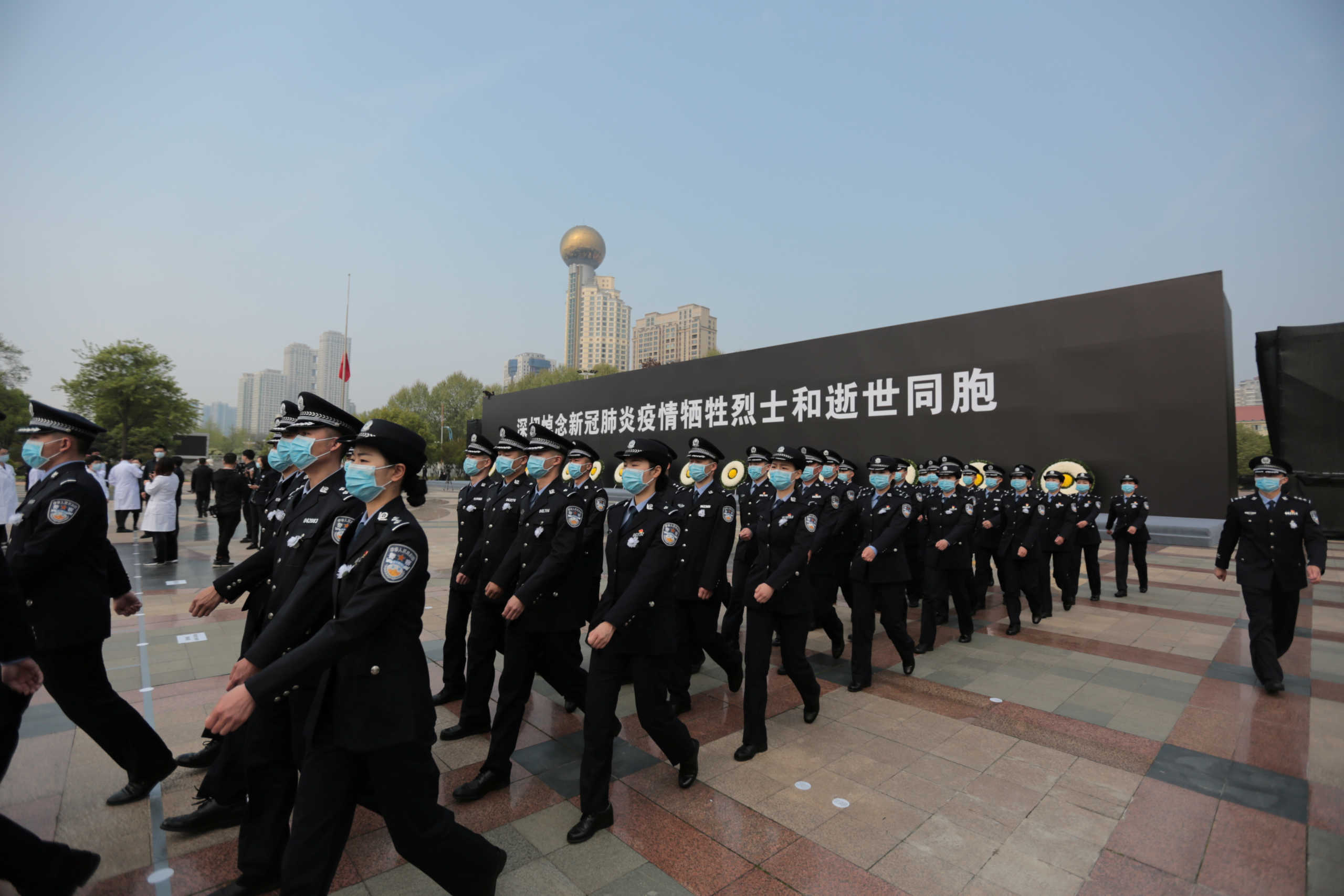 Police officers attend a ceremony mourning those who died of the coronavirus disease (COVID-19) as China holds a nationwide mourning on the Qingming tomb-sweeping festival, in Wuhan, Hubei province, China April 4, 2020. China Daily via REUTERS  ATTENTION EDITORS - THIS IMAGE WAS PROVIDED BY A THIRD PARTY. CHINA OUT.