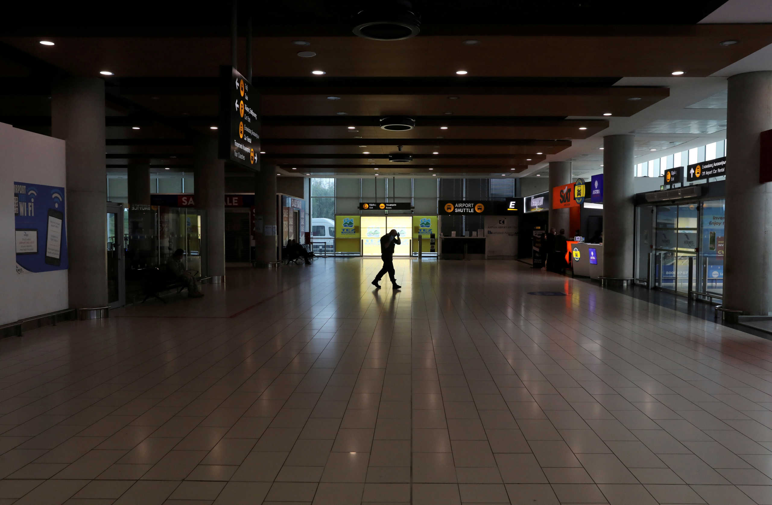 FILE PHOTO: A man walks in an almost empty arrival hall, as Cyprus government bans flights from 28 countries from March 21st  to curb the coronavirus disease (COVID-19), at Larnaca International Airport, Cyprus March 18, 2020. REUTERS