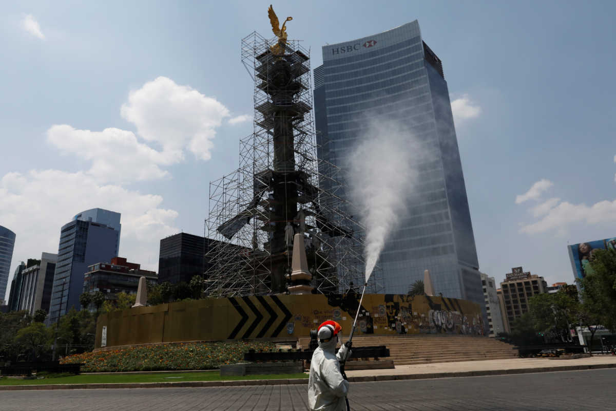 A city employee, wearing protective gear, disinfects an area near to the Angel de la Independencia monument as the coronavirus disease (COVID-19) continues in Mexico City, Mexico April 6, 2020. REUTERS