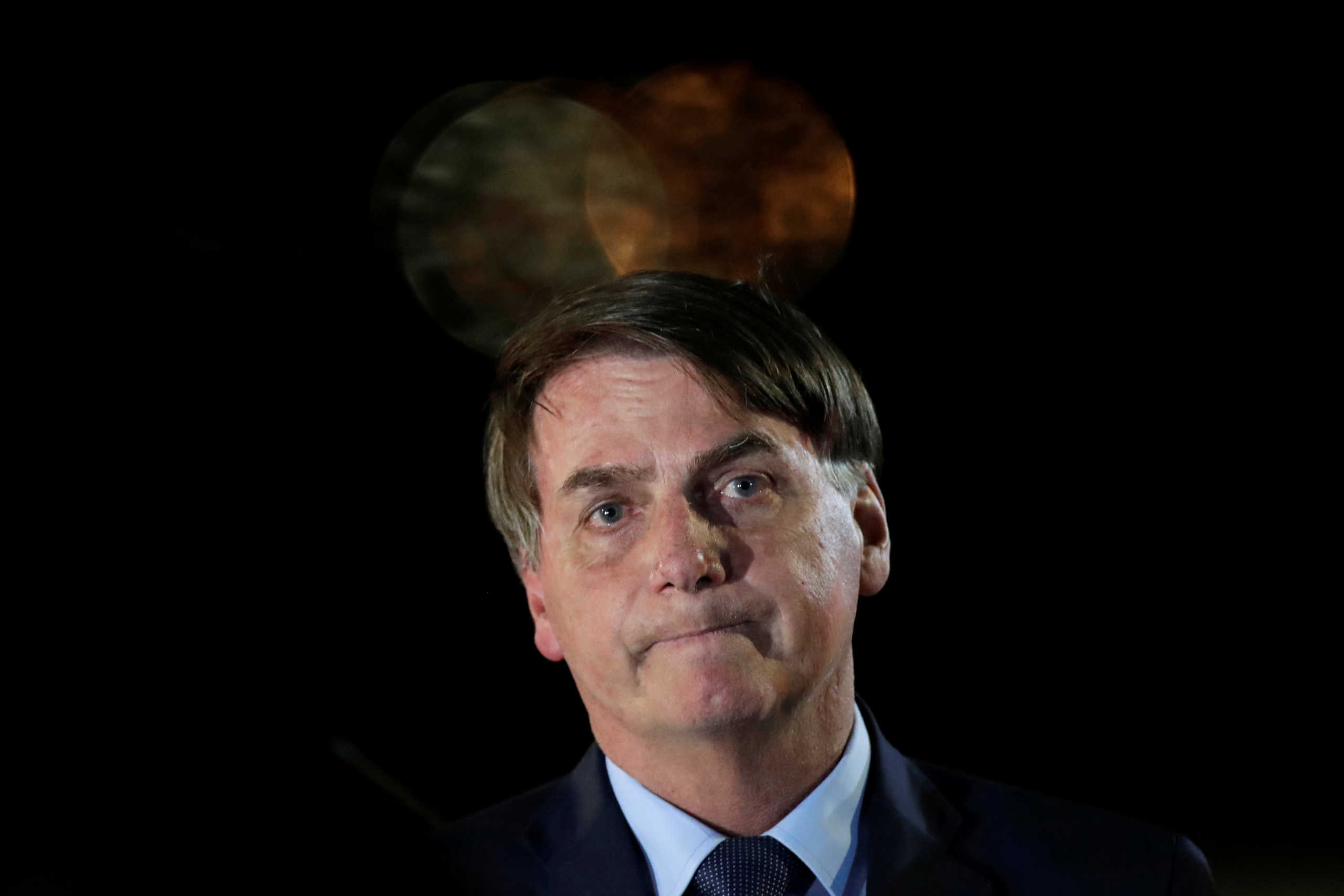 Brazil's President Jair Bolsonaro reacts while meeting supporters as he arrives at Alvorada Palace, amid coronavirus disease (COVID-19) outbreak, in Brasilia, Brazil, April 1, 2020. REUTERS