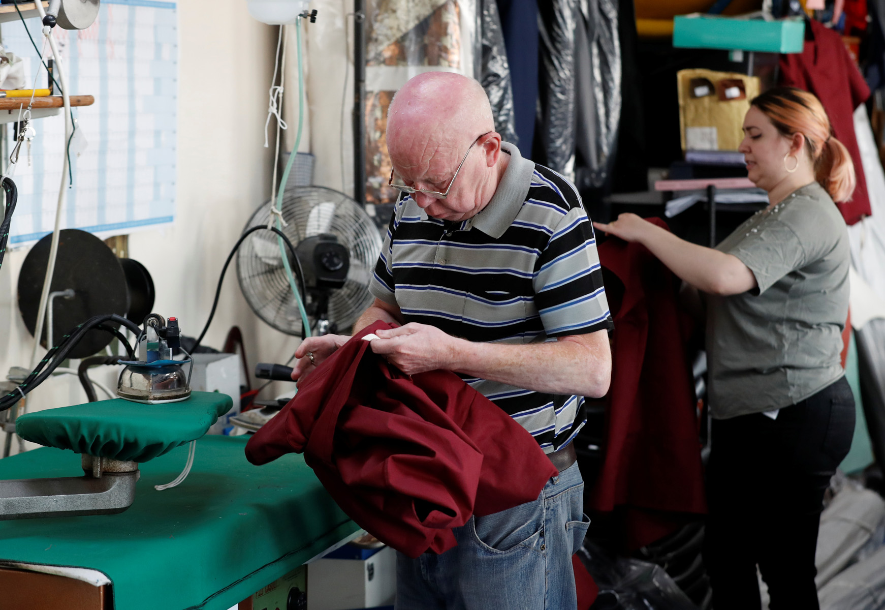 An employee makes medical scrubs at Costello & Son Ltd, a tailor who makes military uniforms, as London-based tailors and costume designers are among the many members of the public using their skills to ensure health workers are adequately equipped to work on the COVID-19 frontline, in London, Britain April 24, 2020. Picture taken April 24, 2020. REUTERS