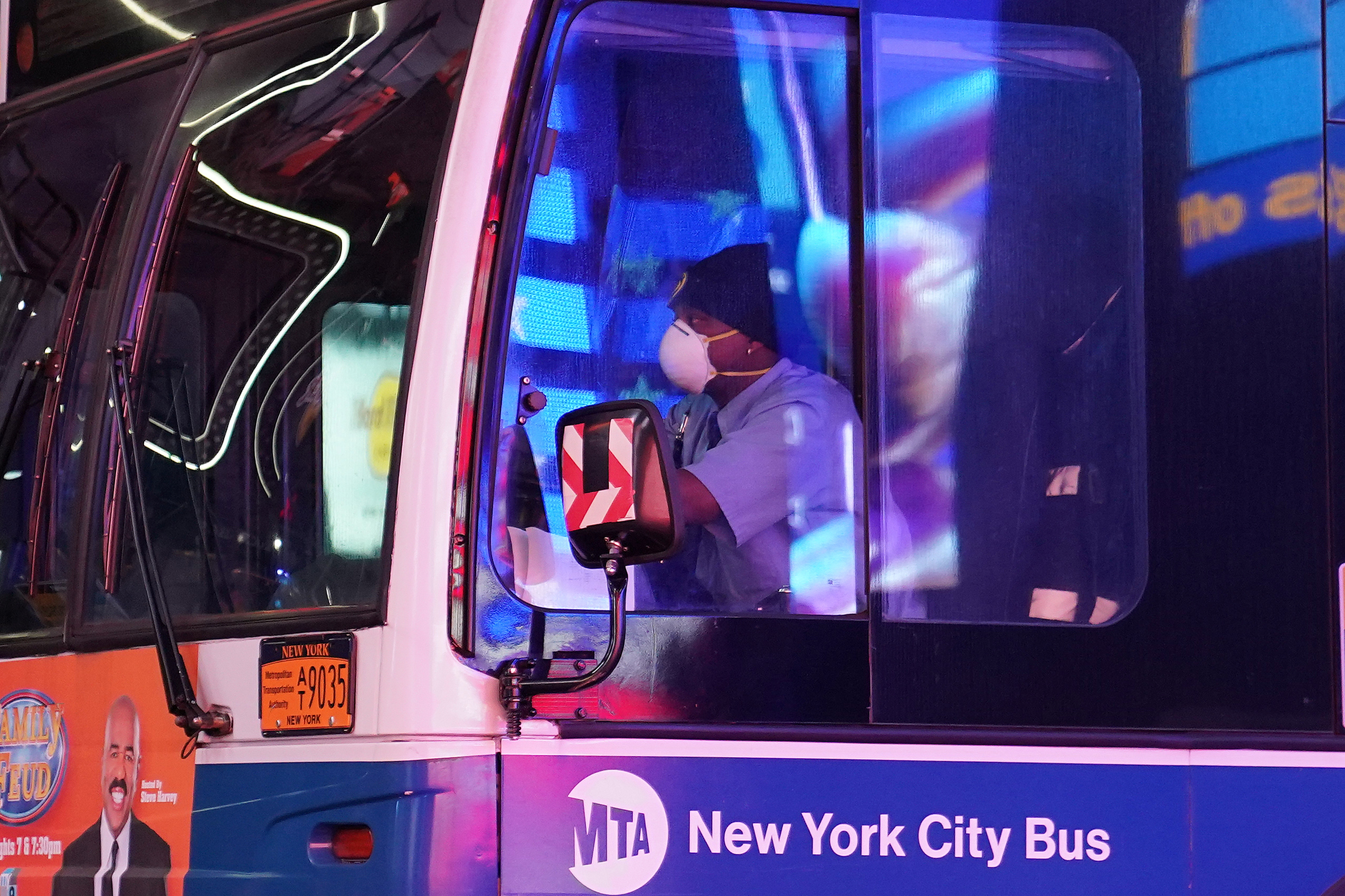 A bus driver wears a mask as he drives though a mostly deserted Times Square during the outbreak of the coronavirus disease (COVID-19), in the Manhattan borough of New York City, New York, U.S., March 31, 2020. REUTERS